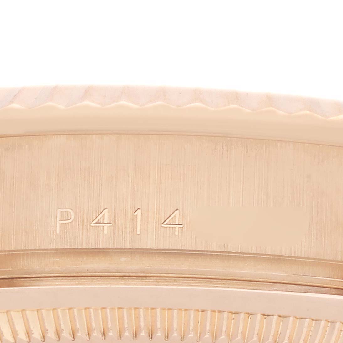 The image shows a close-up of the side of a Rolex President 118235 Men
s Rose Gold Pink Dial 118235 Men
s Rose Gold Pink Dial watch, highlighting the engraved serial number.