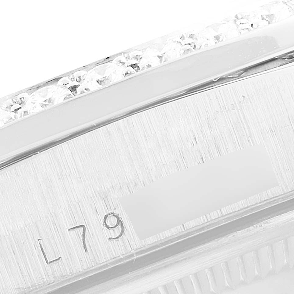 This close-up image shows a partial view of the bezel with diamonds and the serial number of a Rolex President 18346 Men's Platinum Silver Dial 18346 Men's Platinum Silver Dial model.