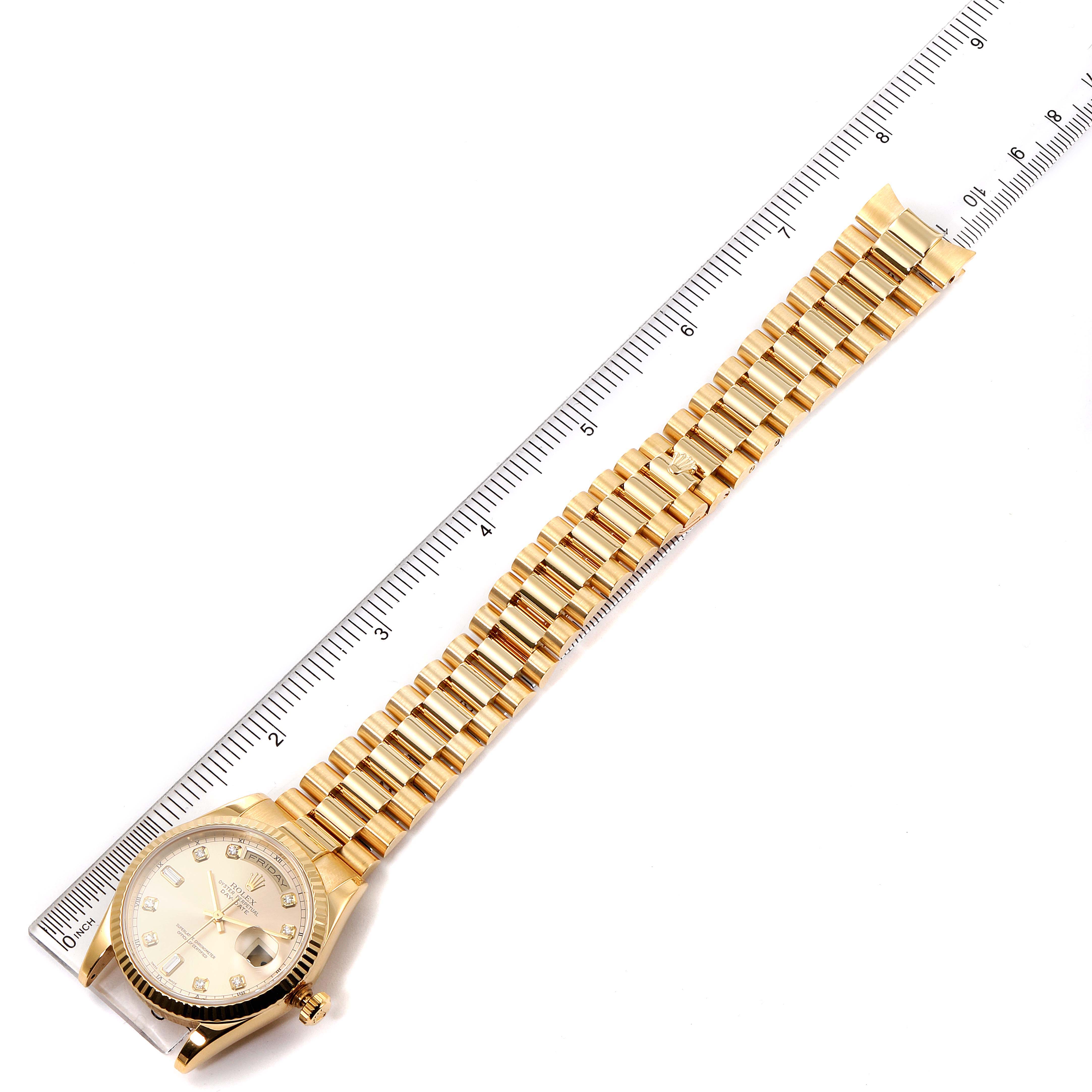 The Rolex President 118238 Men
s Yellow Gold Champagne Dial 118238 Men
s Yellow Gold Champagne Dial model watch is shown at a top-down angle, highlighting its bracelet and dial against a ruler.