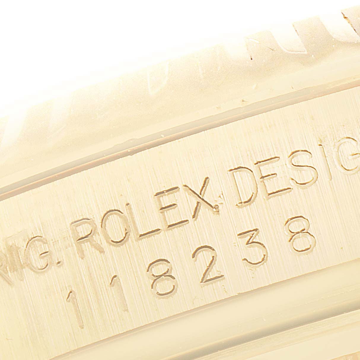 The image shows a close-up angle of the engraved "ROLEX DESIGN" and model number on the case of a Rolex President 118238 Men
s Yellow Gold Champagne Dial 118238 Men
s Yellow Gold Champagne Dial watch.