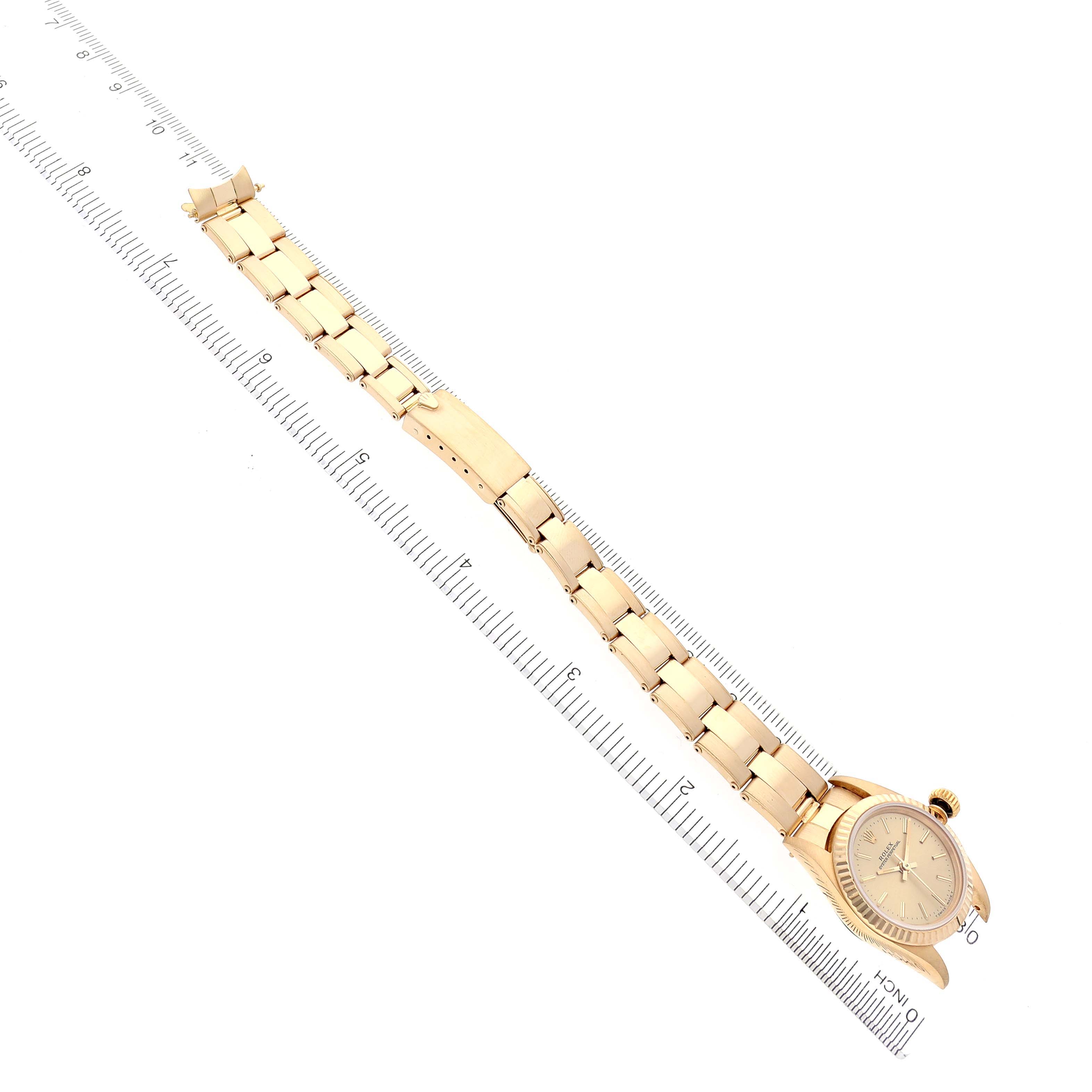 The Rolex President 67198 Women's Yellow Gold Champagne Dial 67198 Women's Yellow Gold Champagne Dial model watch is shown in a top-down view, highlighting the full bracelet and bezel alongside a measuring ruler.