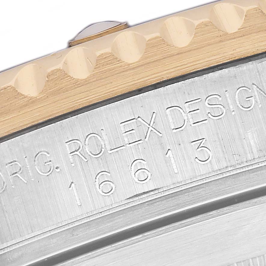 The image shows a close-up of the Rolex Submariner 16613 Men's Steel and Gold (two tone) Blue Dial's bezel and engraved side with model details.