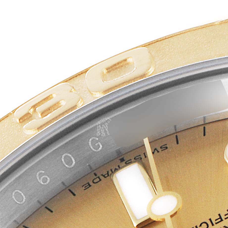 This close-up of the Rolex Yacht-Master 16623 Men
s Steel and Gold (two tone) Champagne Dial 16623 Men
s Steel and Gold (two tone) Champagne Dial watch shows its bezel, part of the dial, and part of a hand.