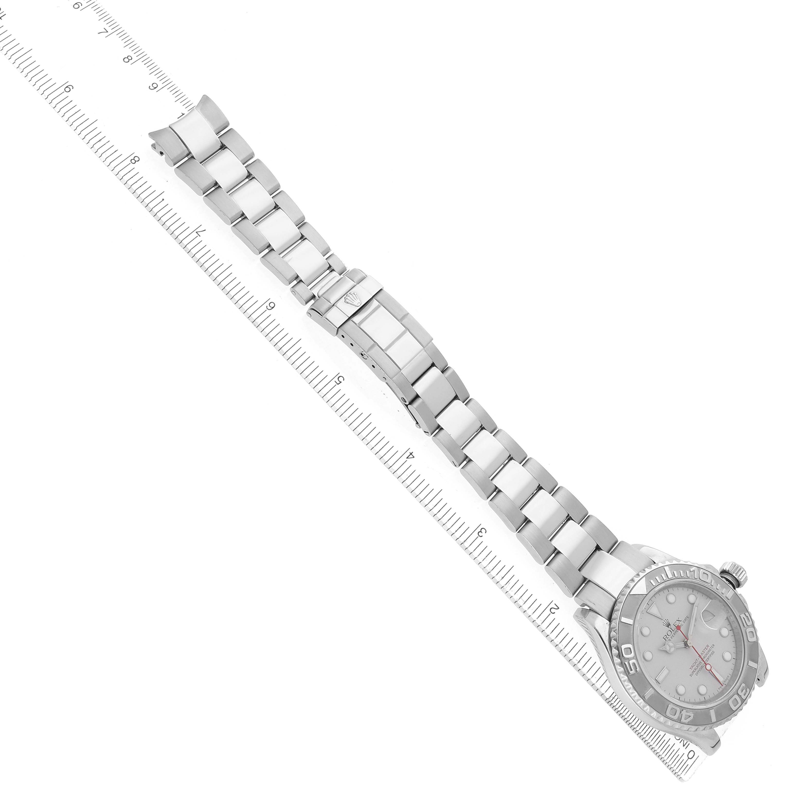 The Rolex Yacht-Master 16622 Men's Stainless Steel Silver Dial watch is shown from an overhead angle, displaying the bracelet, clasp, and face next to a ruler for scale.