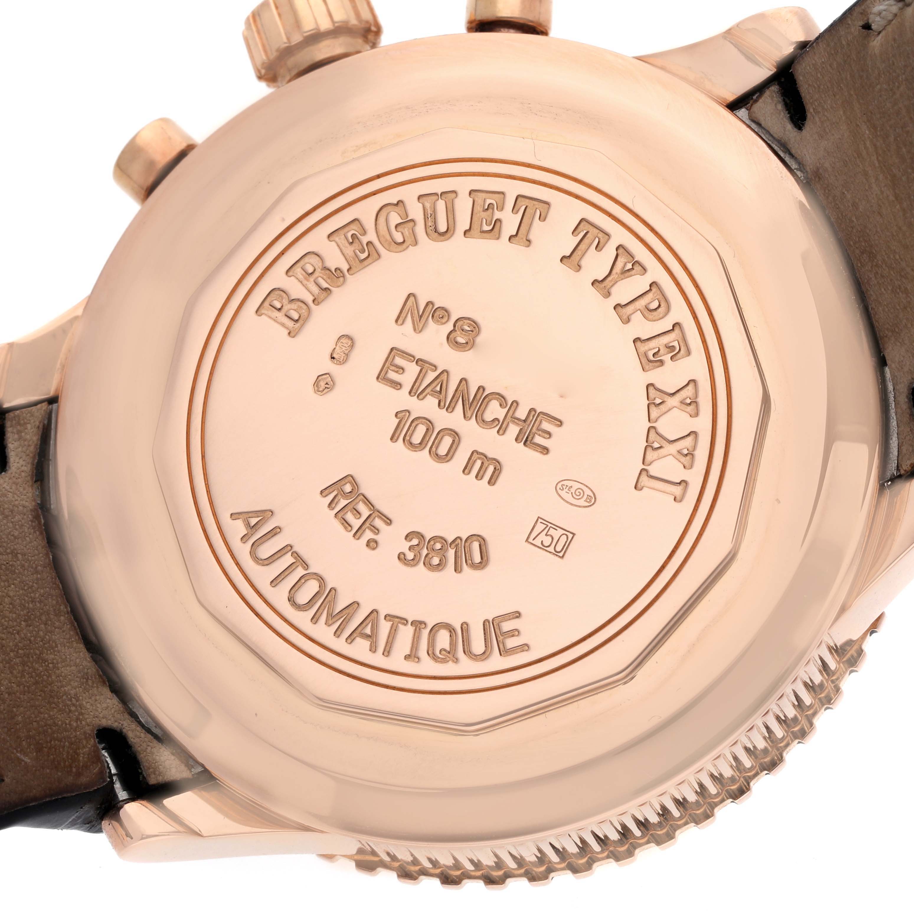 The image shows the back case of a Breguet Type XXI watch, displaying engravings and the leather strap connection.