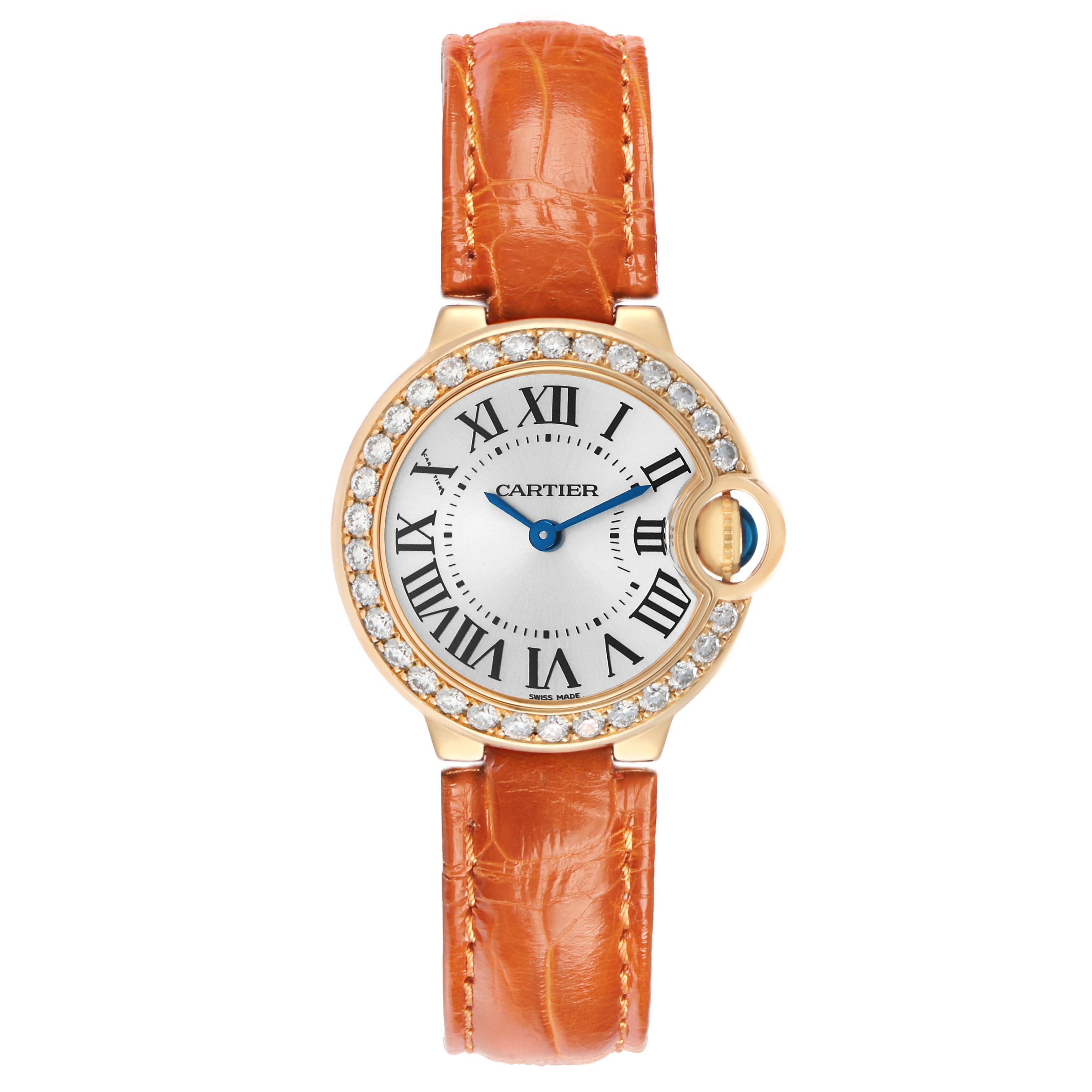 The Cartier Ballon Bleu WE900151 Women's Yellow Gold Silver Dial watch is shown from a top-down angle, displaying its face, diamond bezel, and orange leather strap.