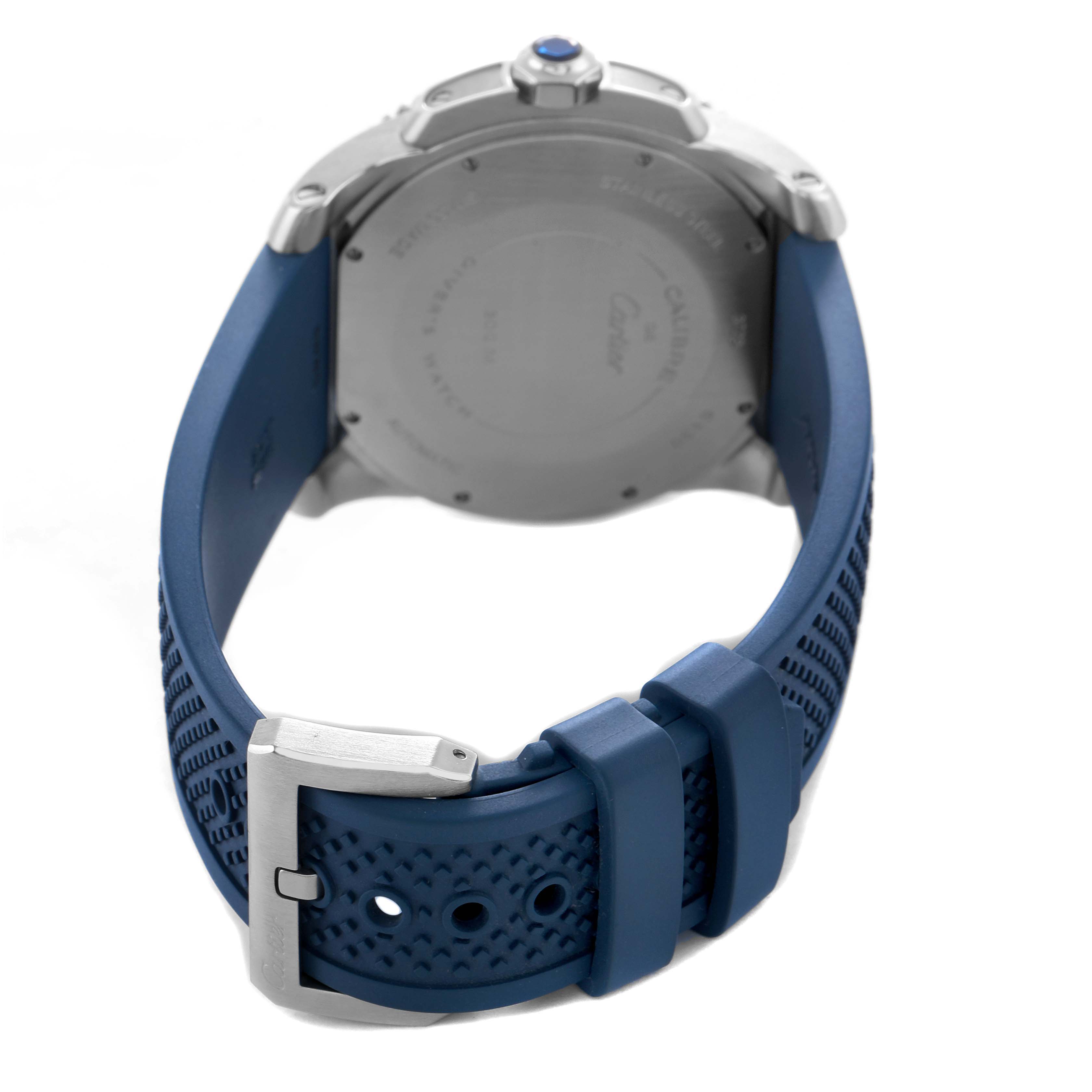 The image shows the back of a Calibre de Cartier watch by Cartier, focusing on the case back and blue strap with buckle.