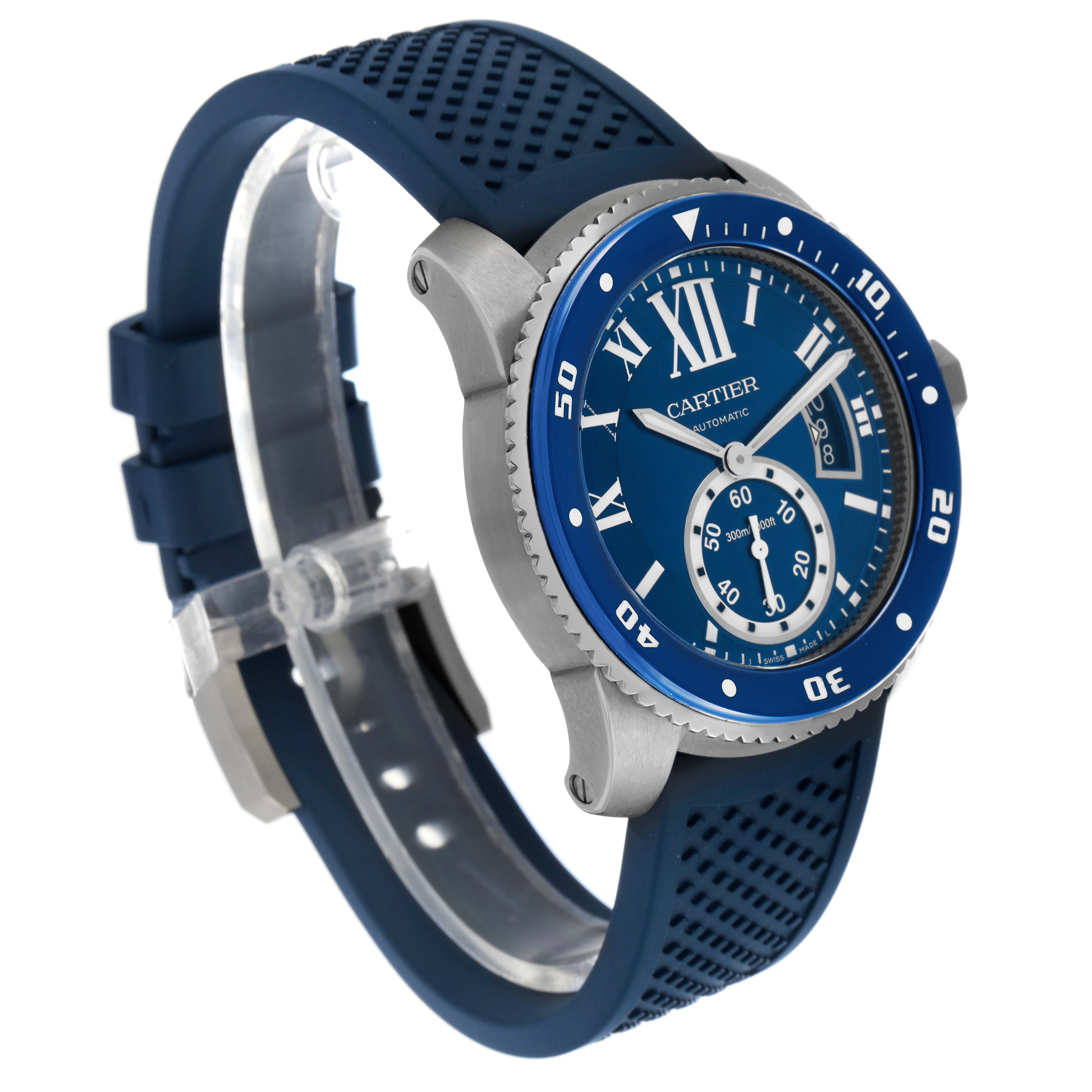 The Calibre de Cartier watch is shown at a three-quarter angle, highlighting the blue dial, rubber strap, crown, and bezel.