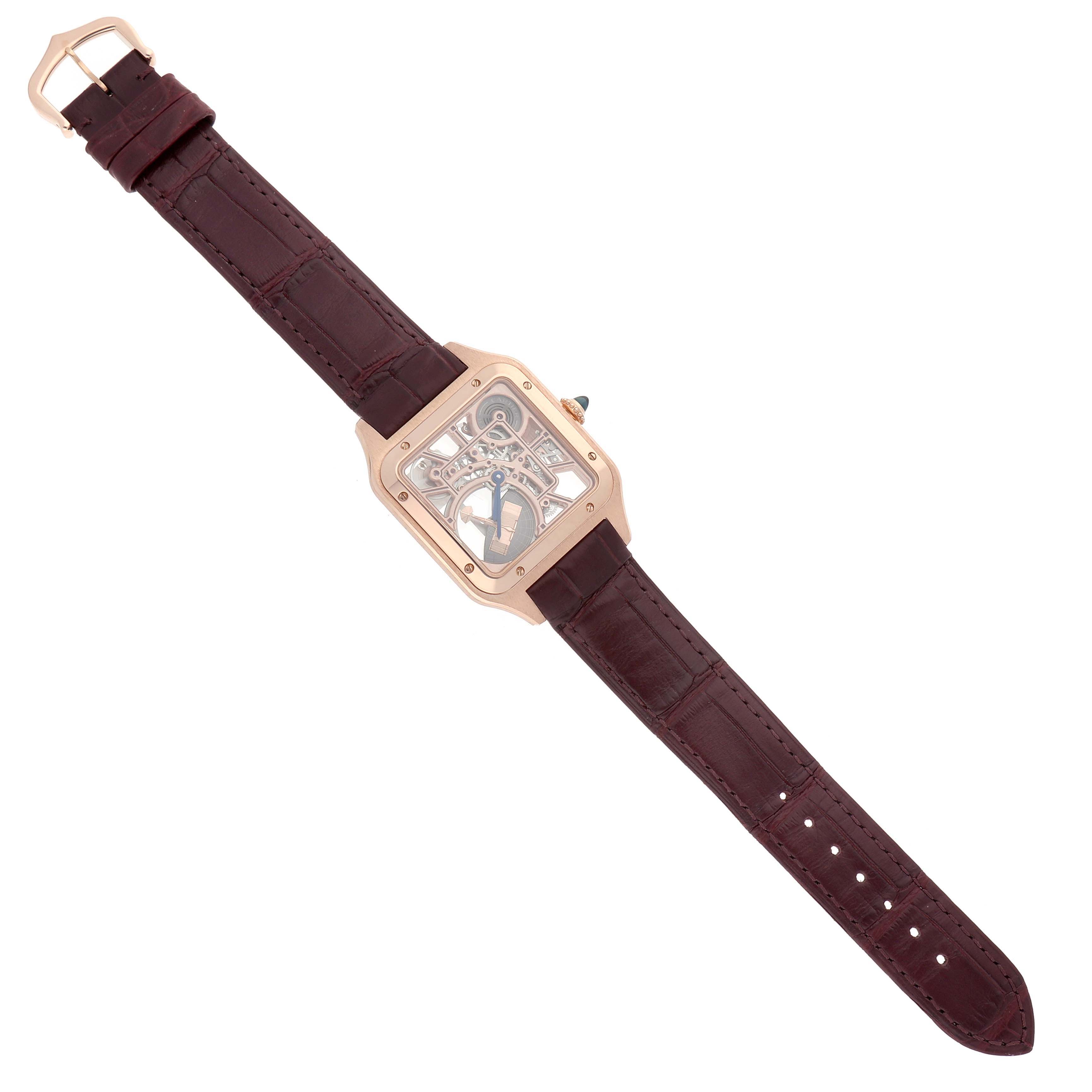 The Cartier Santos Dumont WHSA0030 Men's Rose Gold Transparent Dial watch is shown from a top-down angle, displaying the face, case, and brown strap.