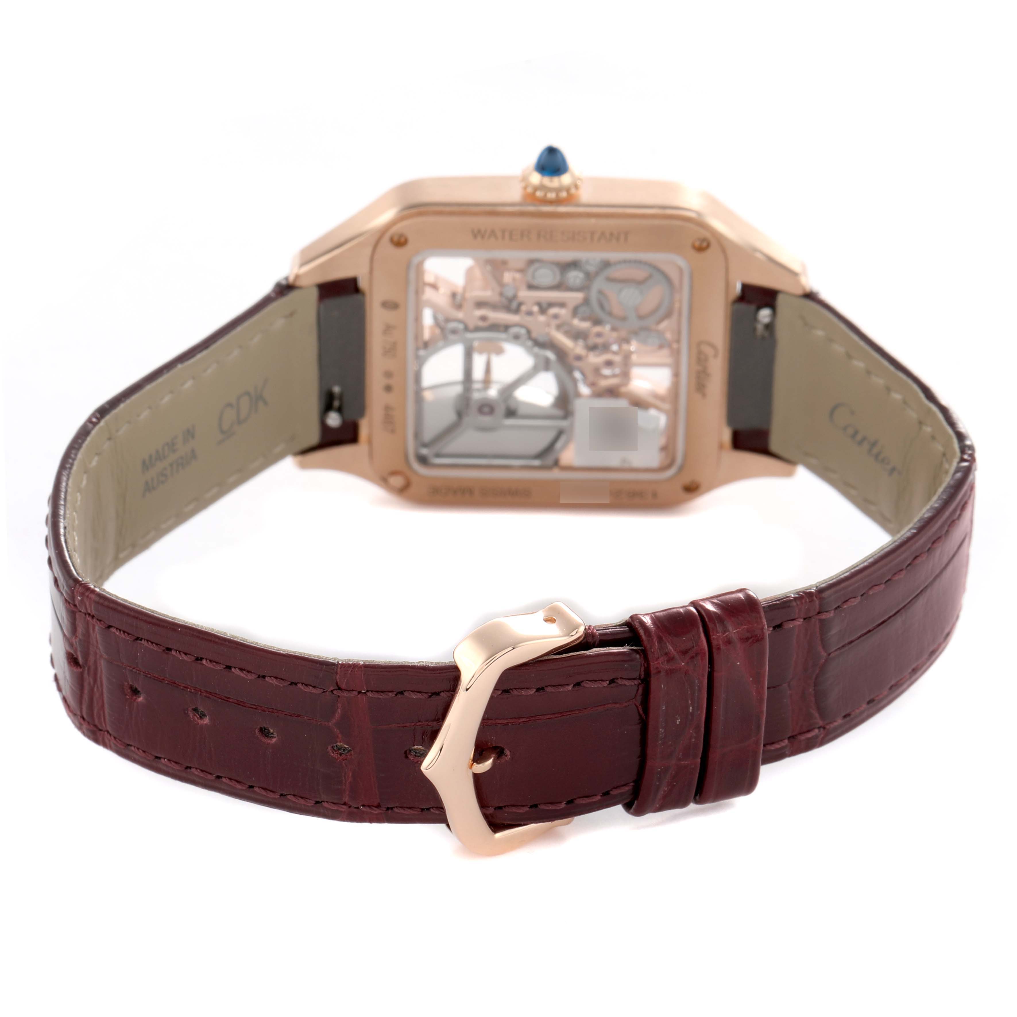 The image shows the back of a Cartier Santos Dumont WHSA0030 Men's Rose Gold Transparent Dial watch, highlighting its transparent case back and leather strap with a buckle.