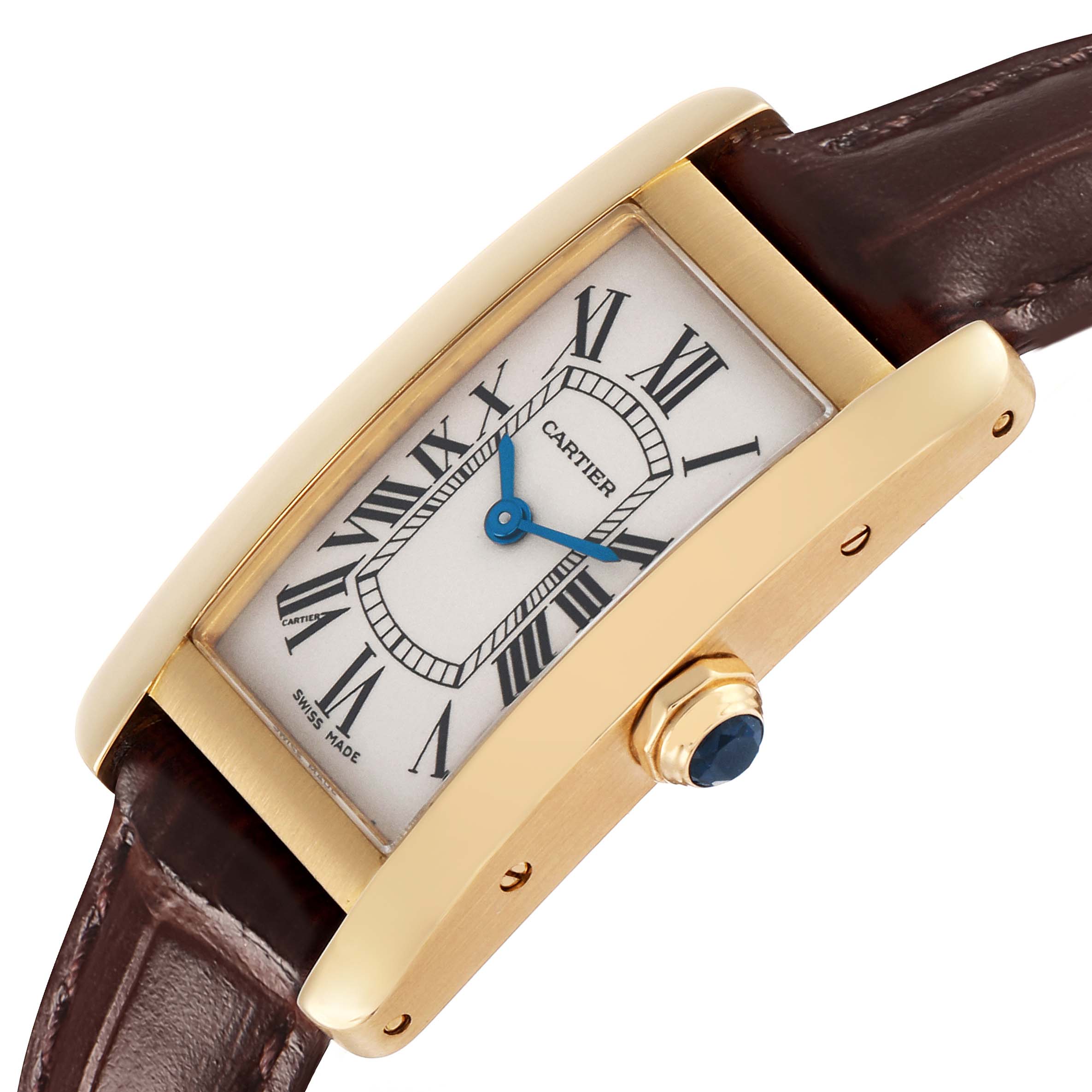 The Cartier Tank Americaine W2601556 Women's Yellow Gold Beige Dial watch is shown at an angle highlighting its rectangular face, Roman numerals, blue hands, crown, and strap.