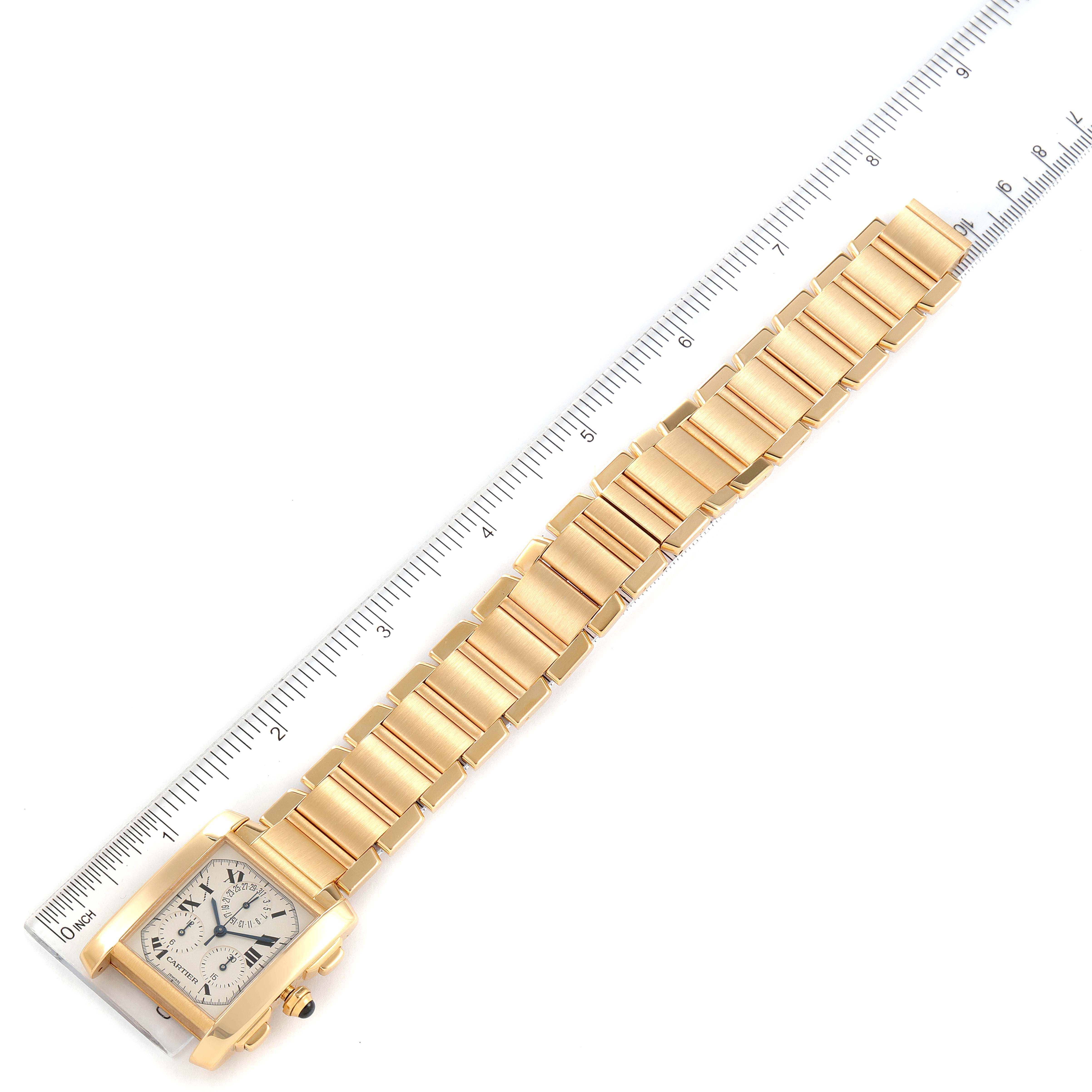 The image shows a Cartier Tank Francaise W50005R2 Men's Yellow Gold Silver Dial W50005R2 Men's Yellow Gold Silver Dial watch laid flat with its gold bracelet, placed next to a ruler for scale.