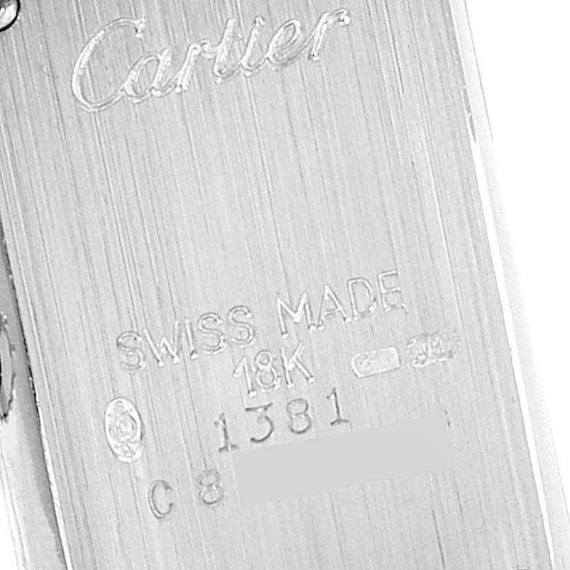This image shows the backside of a Tank Americaine watch by Cartier, displaying its engravings and markings.