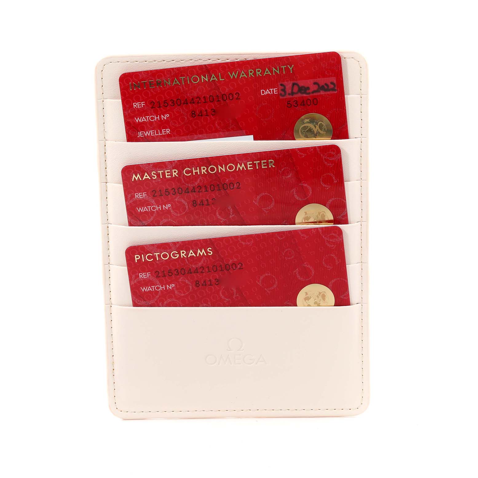 The image shows a holder containing three red cards (International Warranty, Master Chronometer, and Pictograms) for an Omega Planet Ocean 215.30.44.21.01.002 Men
s Stainless Steel Black Dial 215.30.44.21.01.002 Men
s Stainless Steel Black Dial watch.