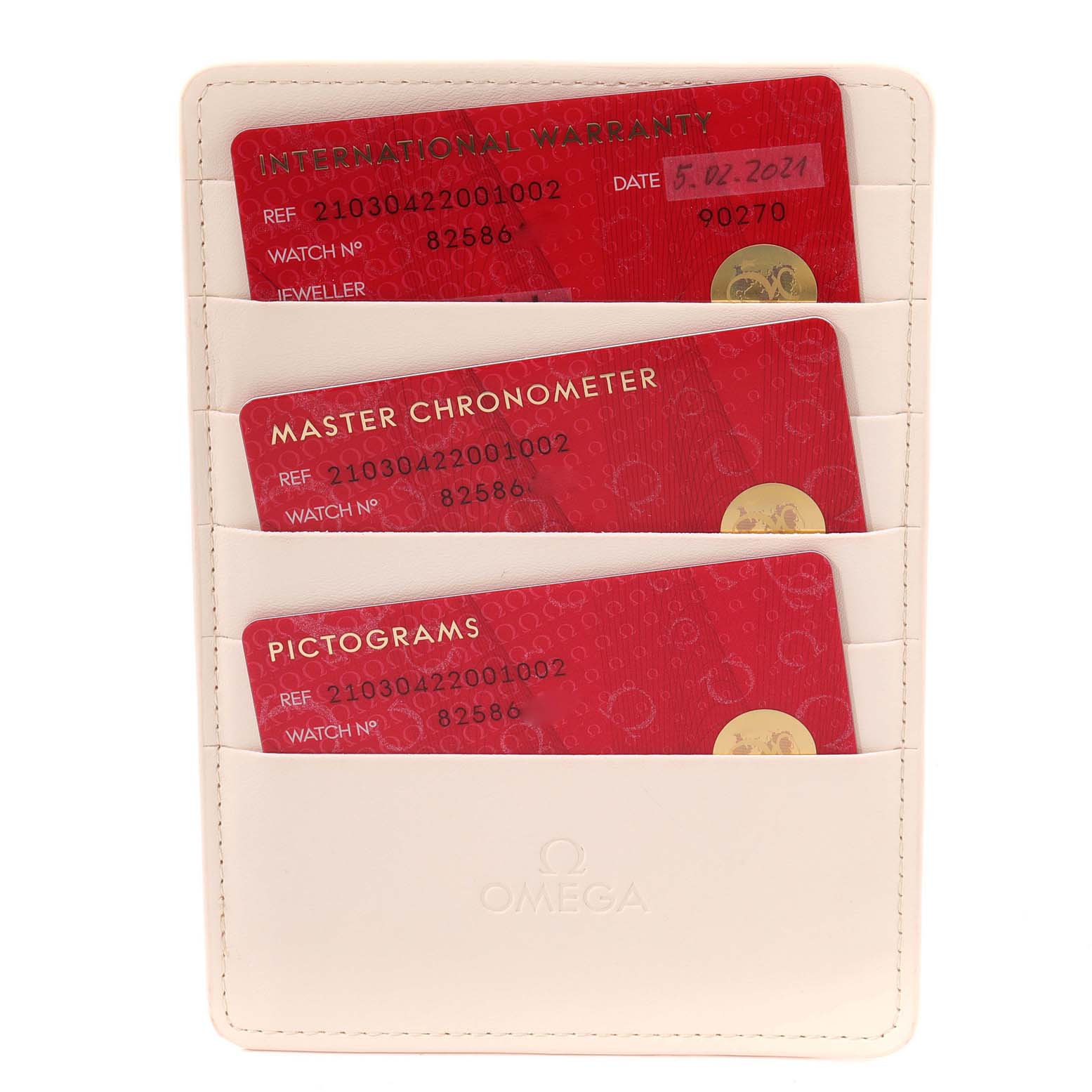 This image shows a white Omega cardholder with three red cards labeled "International Warranty," "Master Chronometer," and "Pictograms."