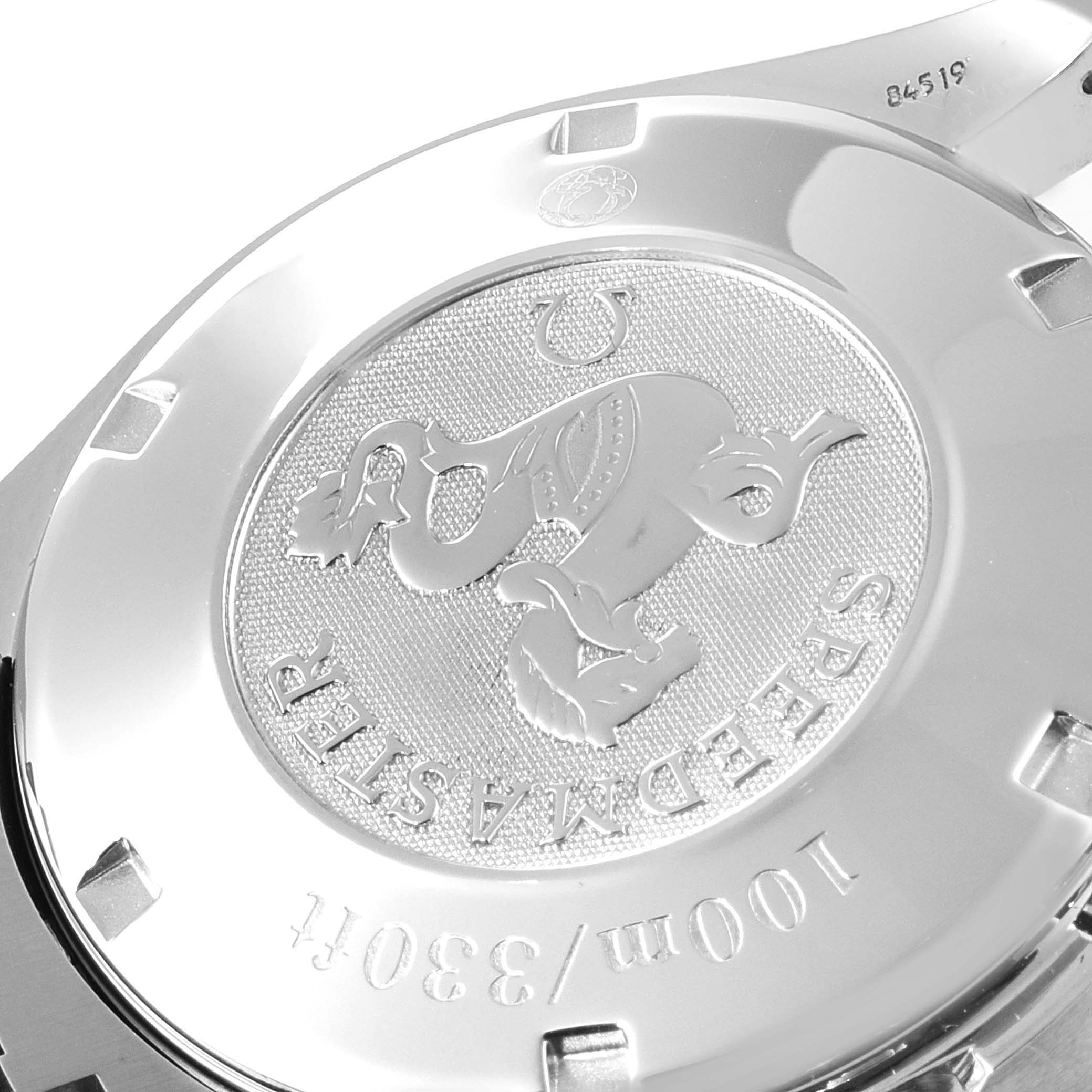 The image shows the back case of an Omega Speedmaster 3210.51.00 Men
s Stainless Steel Black Dial 3210.51.00 Men
s Stainless Steel Black Dial watch, highlighting the engraved emblem and text.