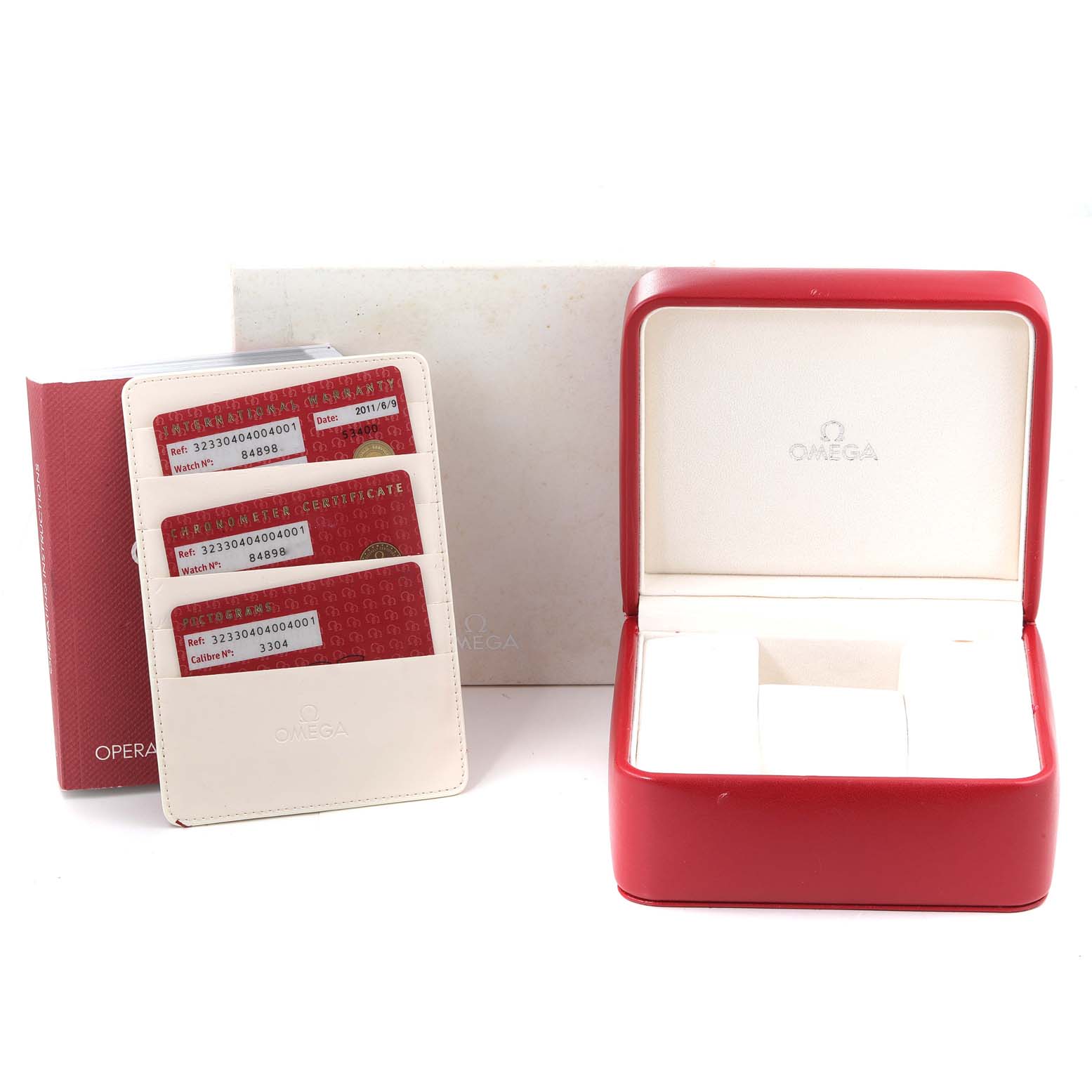 The image shows the accessories of an Omega Speedmaster 323.30.40.40.04.001 Men's Stainless Steel White Dial 323.30.40.40.04.001 Men's Stainless Steel White Dial, including its red and white watch box, operation manual, and warranty cards.