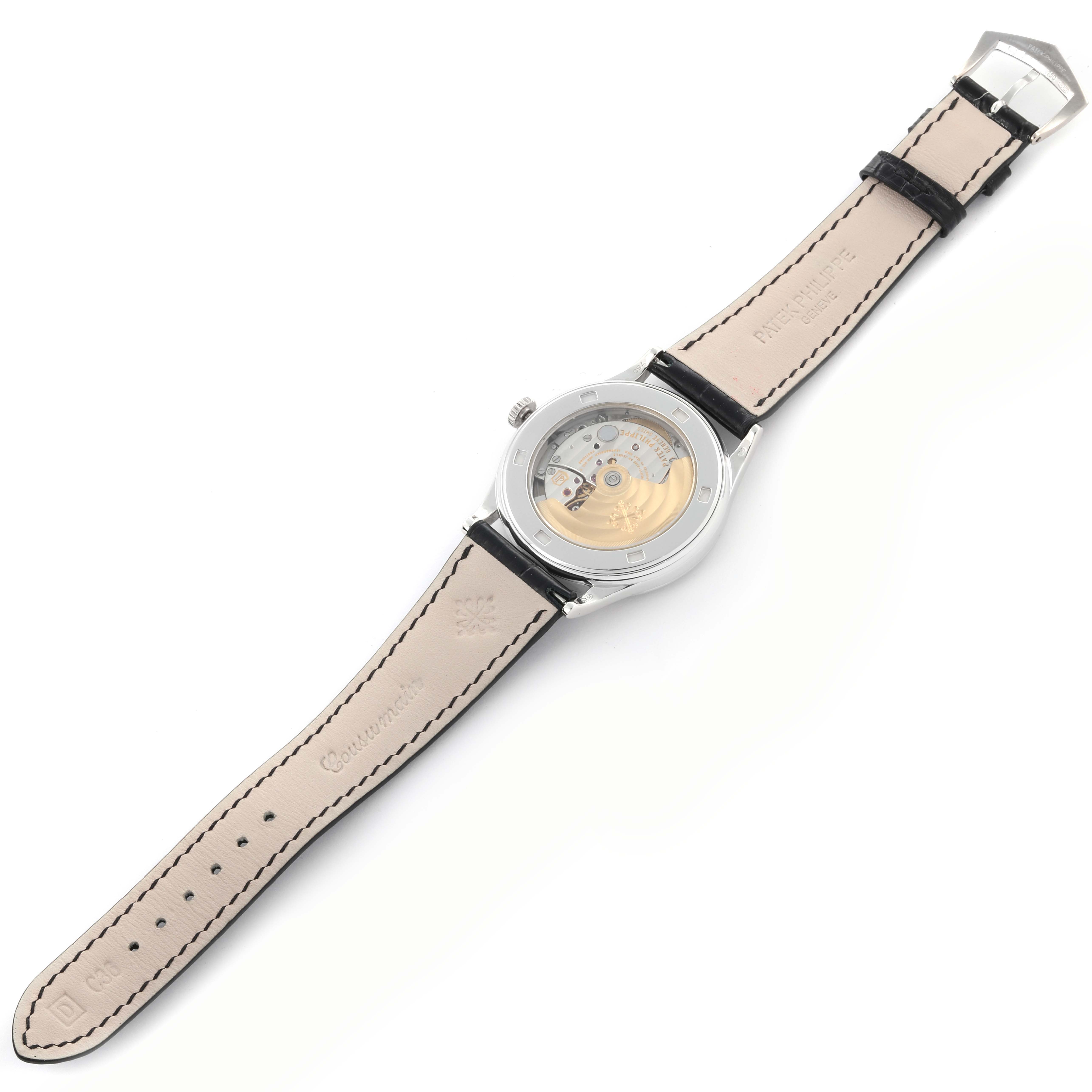 The back view of the Patek Philippe Calatrava 5297G-001 Men's White Gold Black Dial 5297G-001 Men's White Gold Black Dial watch shows the movement and leather strap with stitching.