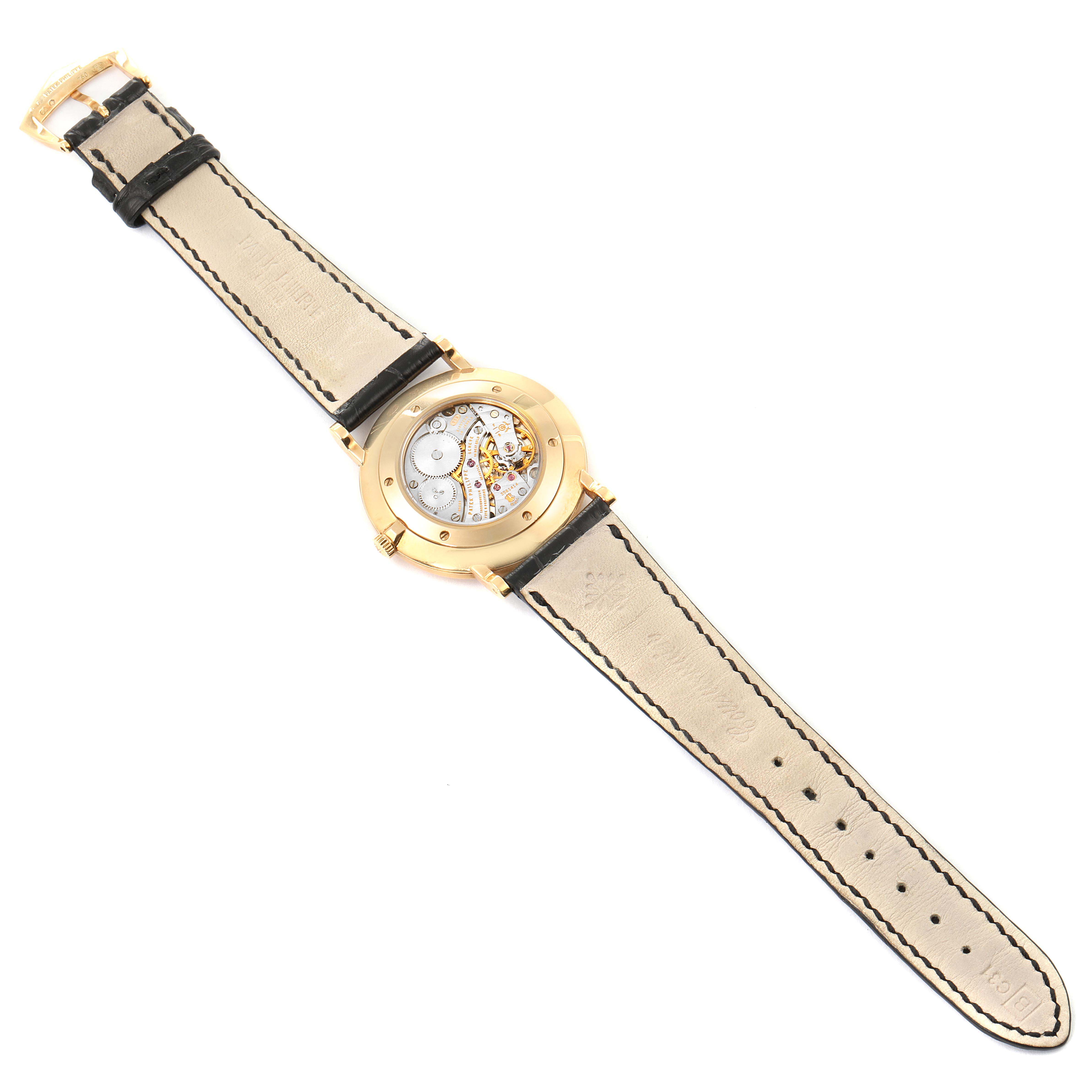 The image shows the back view of a Patek Philippe Calatrava 5119J Men's Yellow Gold White Dial 5119J Men's Yellow Gold White Dial watch, displaying its movement mechanism and leather strap.