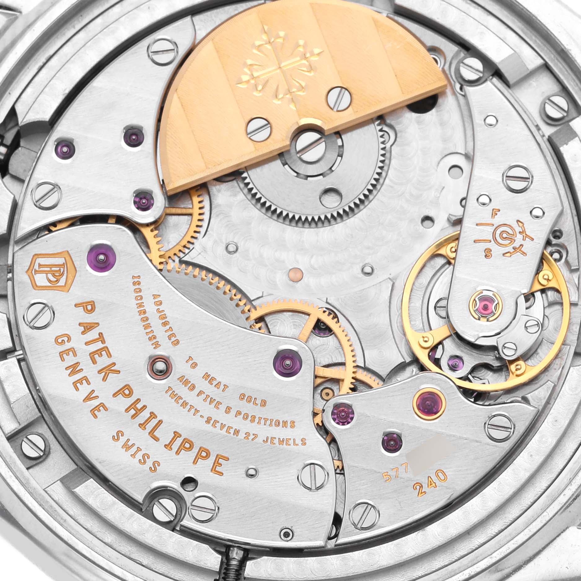 The image shows a close-up of the movement of a Patek Philippe Complications 5140P-001 Men's Platinum Blue Dial 5140P-001 Men's Platinum Blue Dial watch, highlighting gears and inscriptions.