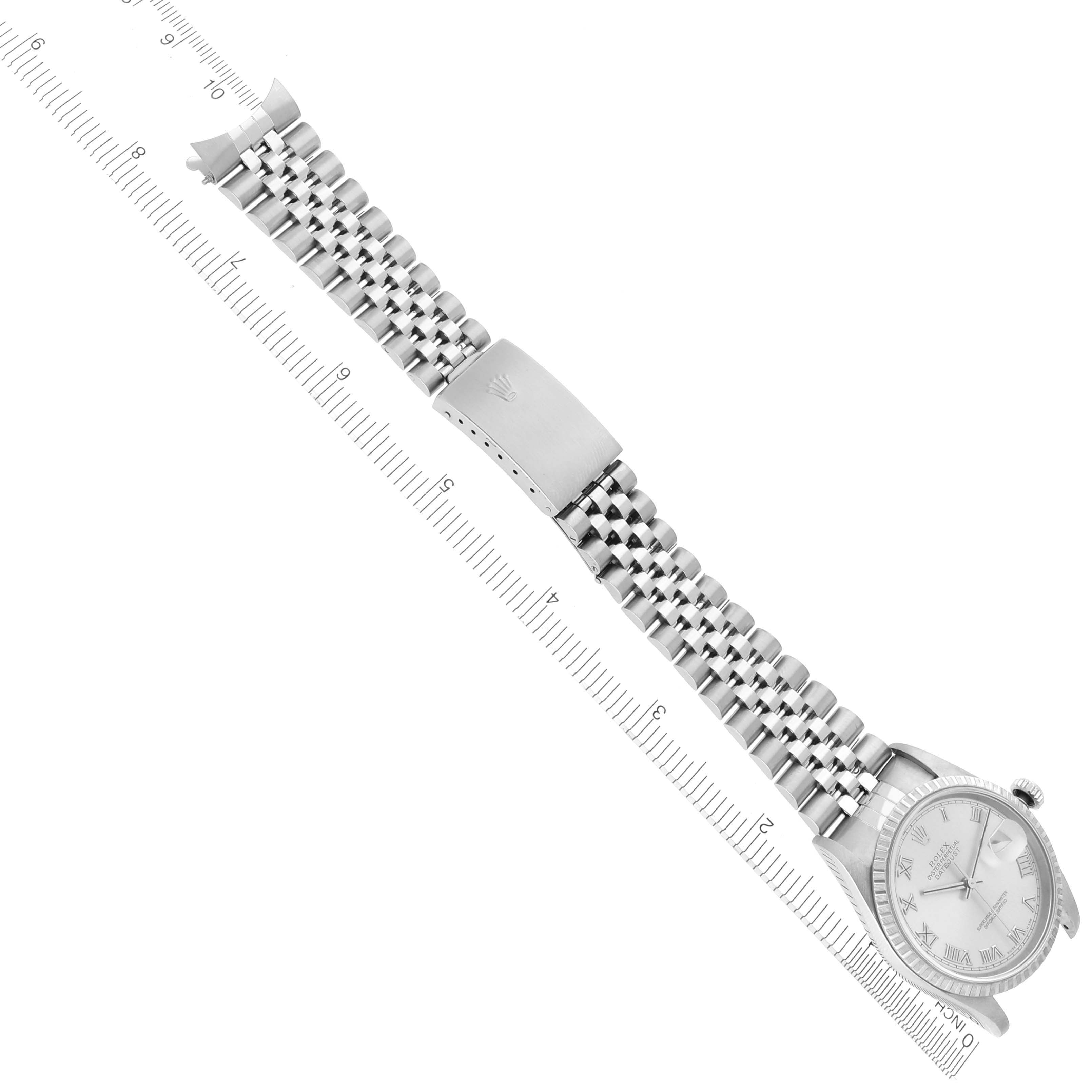 The Rolex Datejust 16220 Men's Stainless Steel Silver Dial 16220 Men's Stainless Steel Silver Dial watch is shown from above, highlighting its full bracelet and clasp alongside a ruler for scale.
