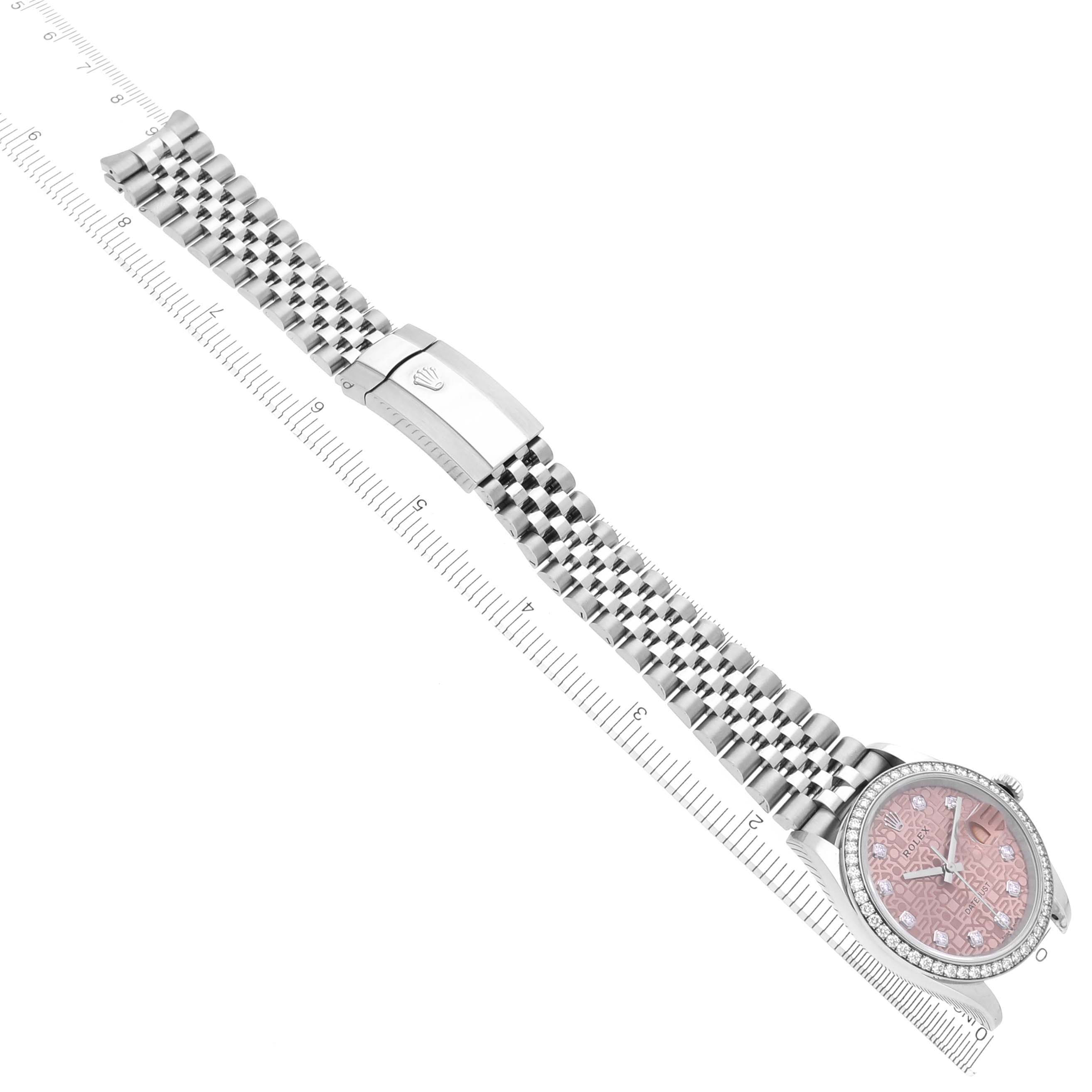 The Rolex Datejust 126284 Men's Stainless Steel Pink Dial 126284 Men's Stainless Steel Pink Dial watch is shown from an overhead angle displaying the dial, bracelet, and clasp alongside a ruler for scale.