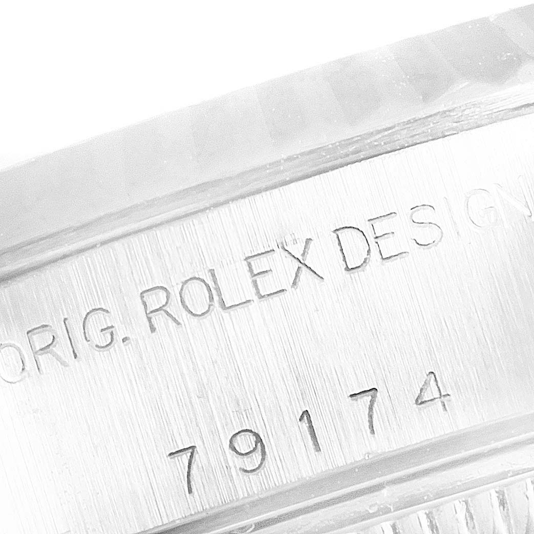 The image shows an engraved serial number and "ORIG. ROLEX DESIGN" on the case back of a Rolex Datejust 79174 Women
s Stainless Steel Blue Dial 79174 Women
s Stainless Steel Blue Dial watch.
