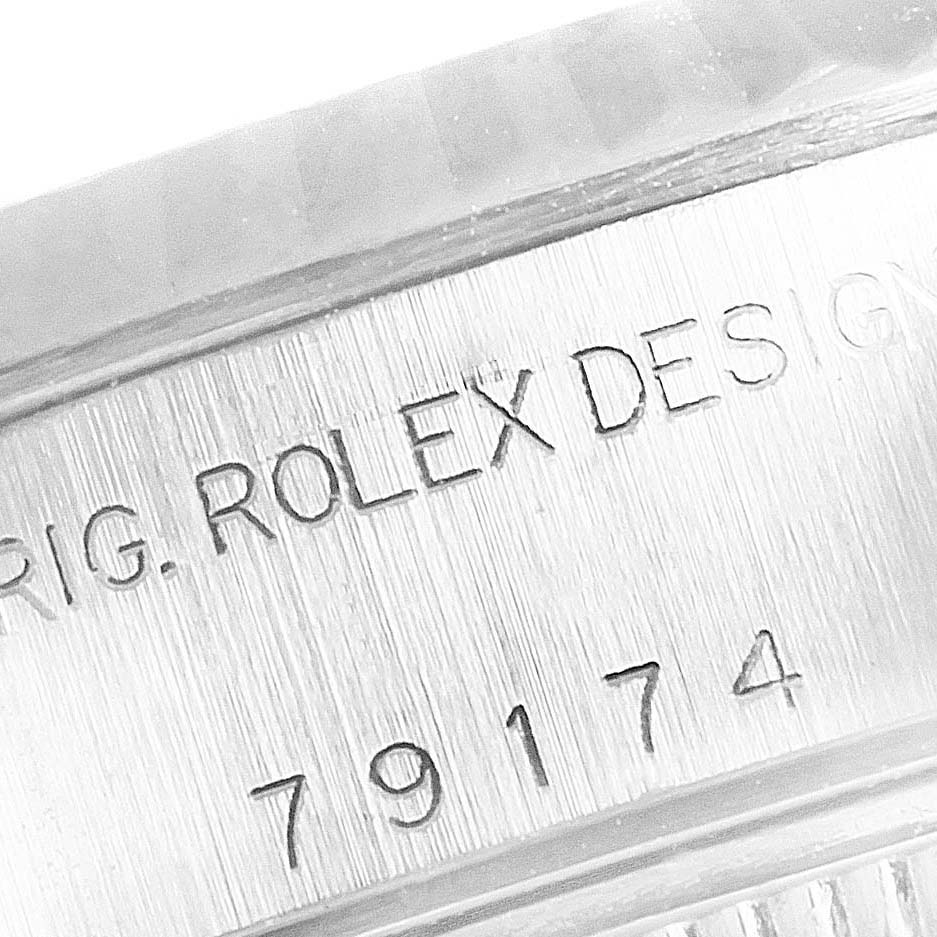 The image shows a close-up view of the serial number and branding engraved on the case of a Rolex Datejust 79174 Women
s Stainless Steel Mother of Pearl Dial 79174 Women
s Stainless Steel Mother of Pearl Dial watch.