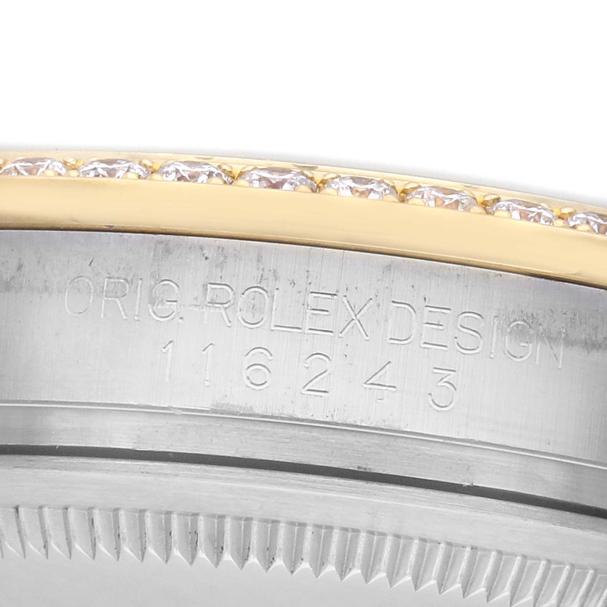 The image shows a close-up of the Rolex Datejust 116243 Men's Steel and Gold (two tone) Silver Dial model's bezel with a diamond setting and engraved design numbers.
