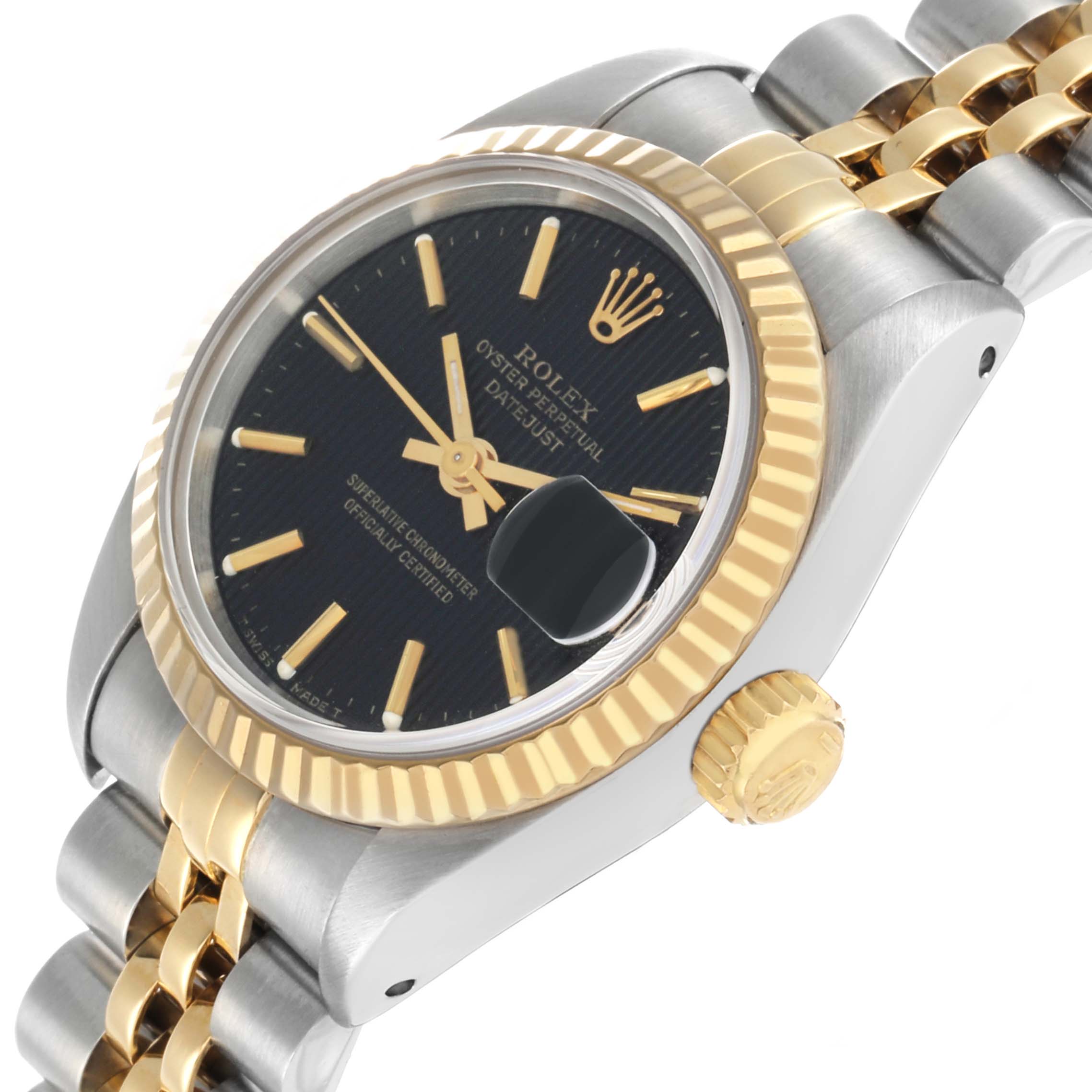 The Rolex Datejust 69173 Women's Steel and Gold (two tone) Black Dial watch is shown at an oblique angle, featuring its black dial, gold bezel, and Jubilee bracelet.