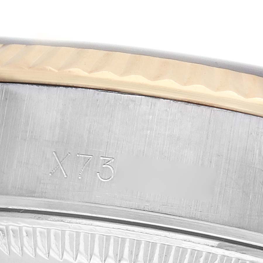 The image shows a close-up of the Rolex Datejust 69173 Women's Steel and Gold (two tone) Black Dial model's serial number and fluted bezel edge.