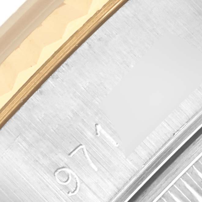 The image shows a close-up of the Rolex Datejust 69173 Women's Steel and Gold (two tone) Champagne Dial 69173 Women's Steel and Gold (two tone) Champagne Dial's case side and part of the bezel with metal engravings.