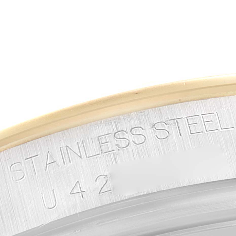 The image shows a close-up of the stainless steel case back edge of the Rolex Daytona 16523 Men
s Steel and Gold (two tone) White Dial 16523 Men
s Steel and Gold (two tone) White Dial watch.