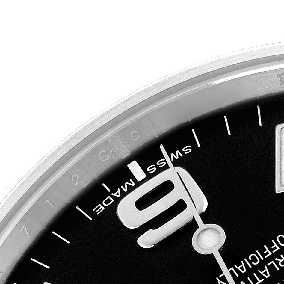 The image shows a close-up of the Rolex Explorer 214270 Men
s Stainless Steel Black Dial 214270 Men
s Stainless Steel Black Dial’s dial with the "6" numeral, part of the minute markers, and the word "Swiss Made".