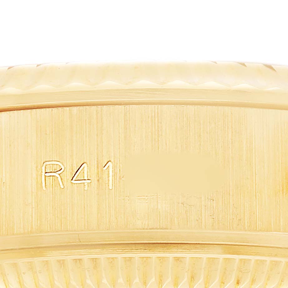 The image shows a close-up of the side of a Rolex Datejust 69178 Women's Yellow Gold Champagne Dial watch, focusing on the bezel and case with engraved markings.