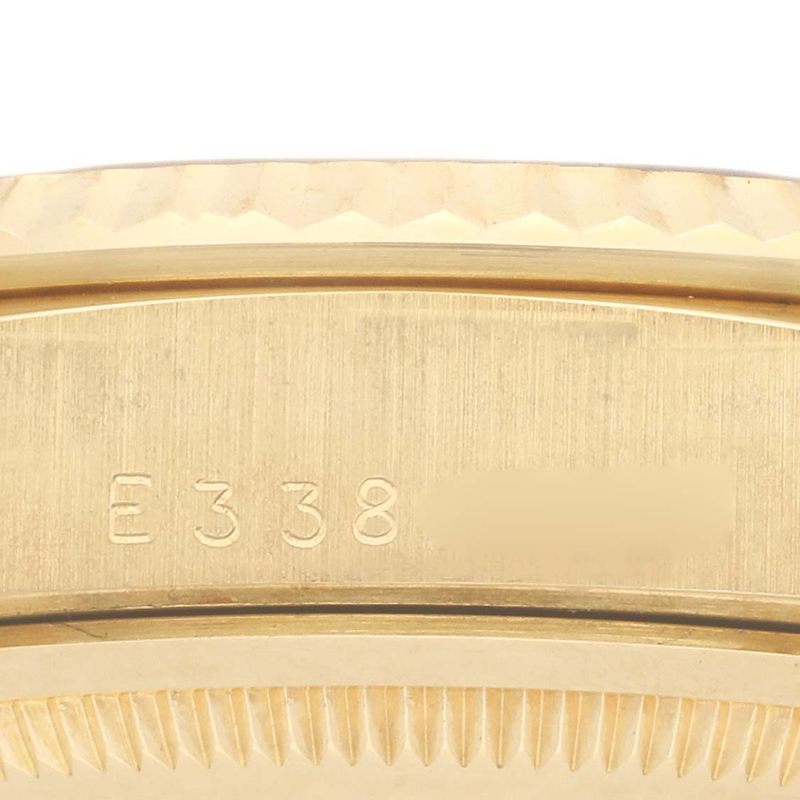The image shows a close-up of the side of a Rolex President 18238 Men's Yellow Gold Black Dial 18238 Men's Yellow Gold Black Dial watch, focusing on the engraved serial number.
