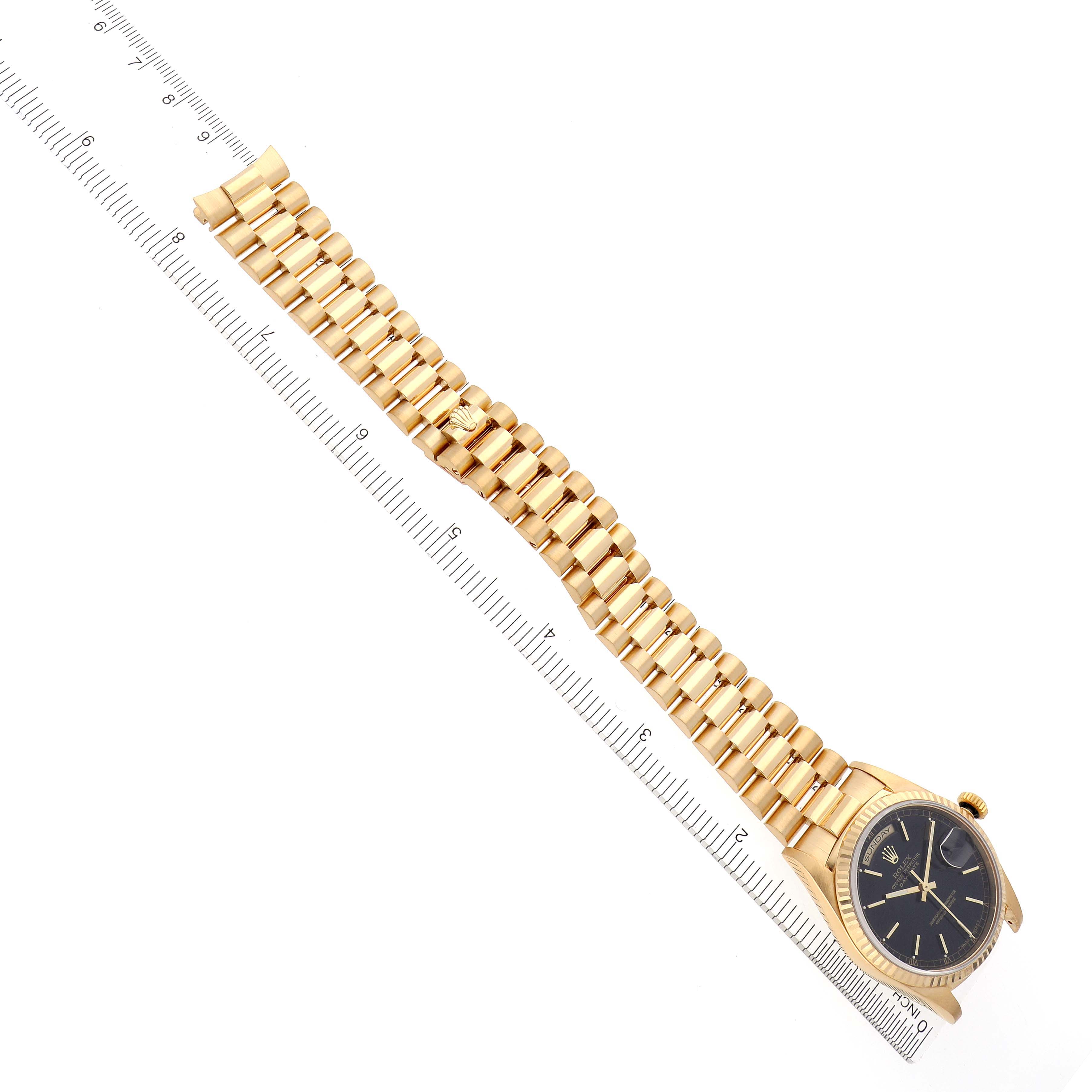 The Rolex President 18238 Men's Yellow Gold Black Dial 18238 Men's Yellow Gold Black Dial watch is shown at an overhead angle highlighting the gold bracelet, bezel, and black dial.