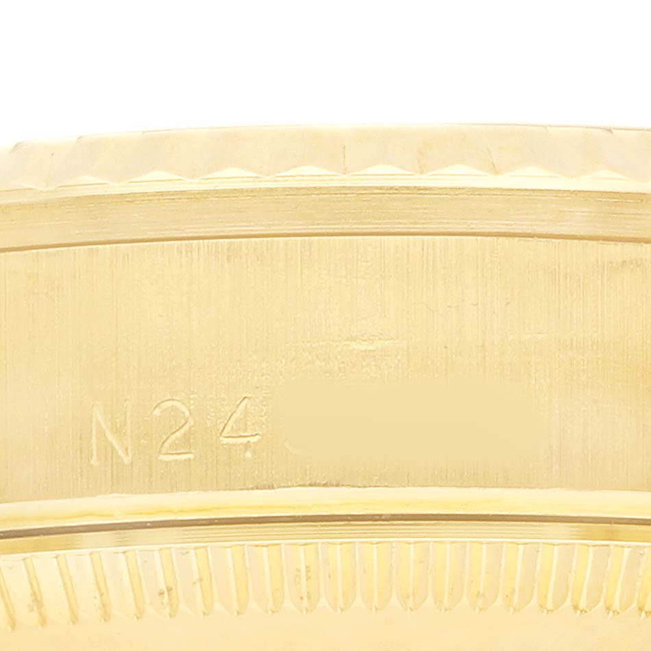 The image shows a close-up of the side of a gold Rolex Mid-Size 68278 Women's Yellow Gold White Dial watch case, highlighting an engraved serial number.