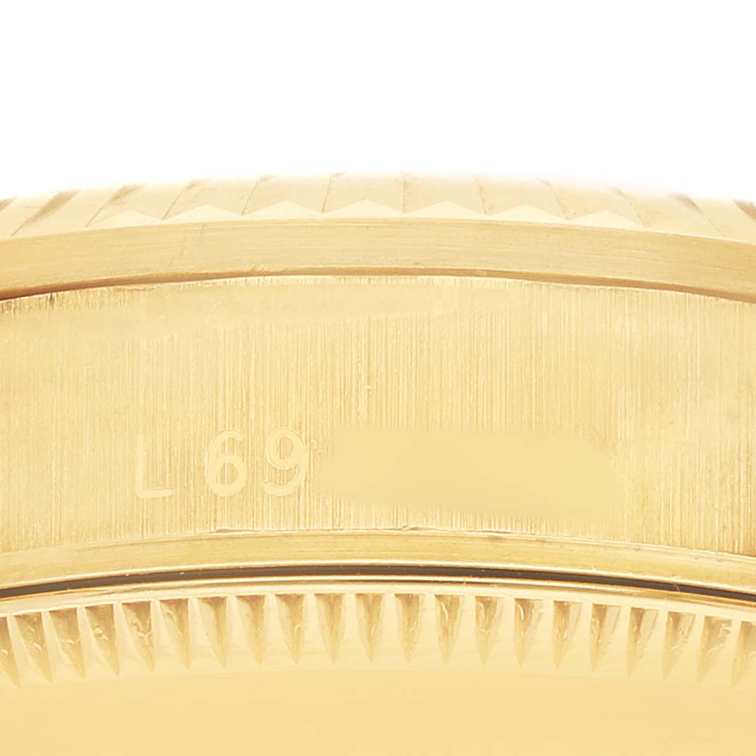 The image shows a close-up of the side of a Rolex Mid-Size 68278 Women's Yellow Gold Champagne Dial watch, highlighting the engraved fluted bezel detail.