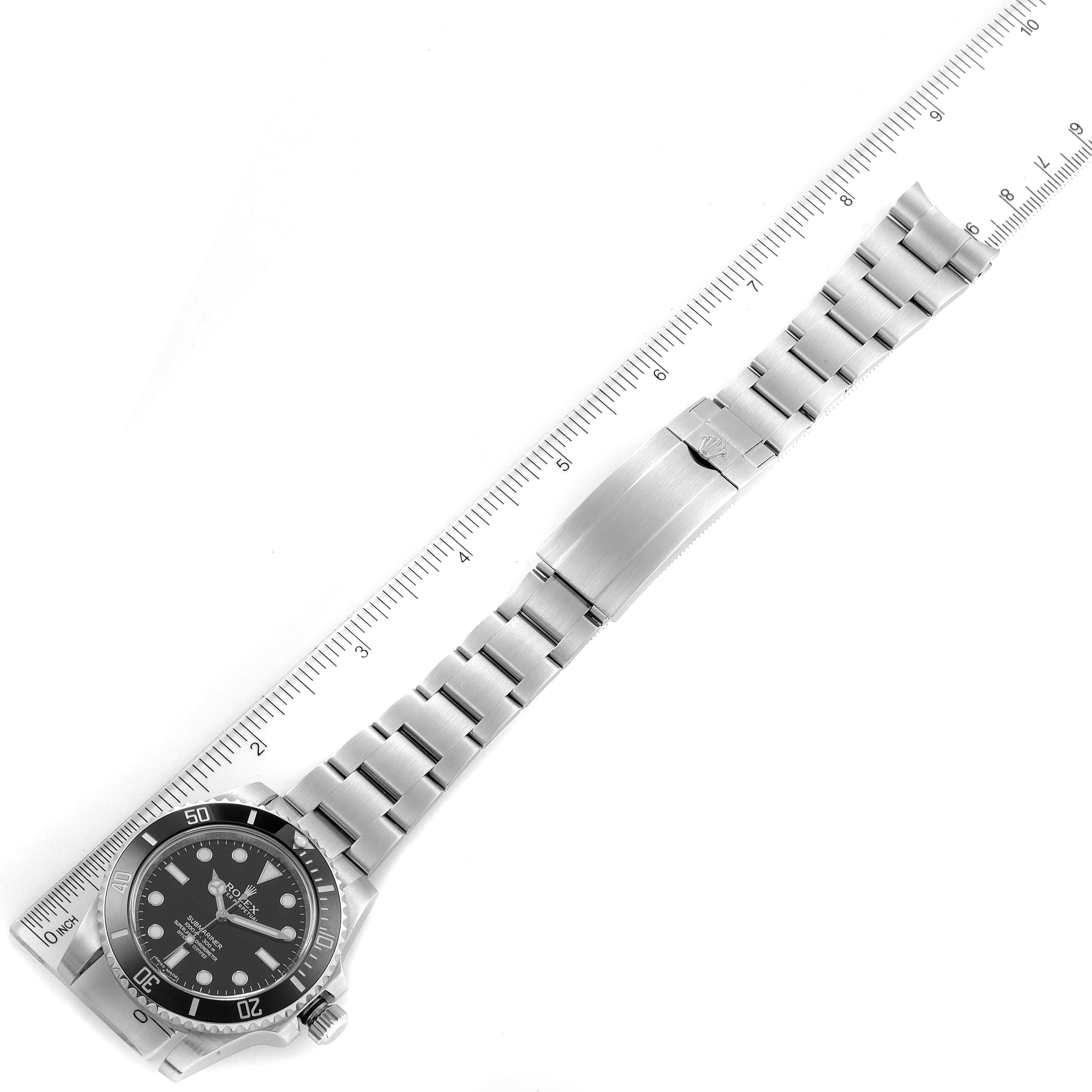 The image shows a top-down view of a Rolex Submariner 114060 Men
s Stainless Steel Black Dial 114060 Men
s Stainless Steel Black Dial watch, displaying its full bracelet, clasp, and dial against a ruler.