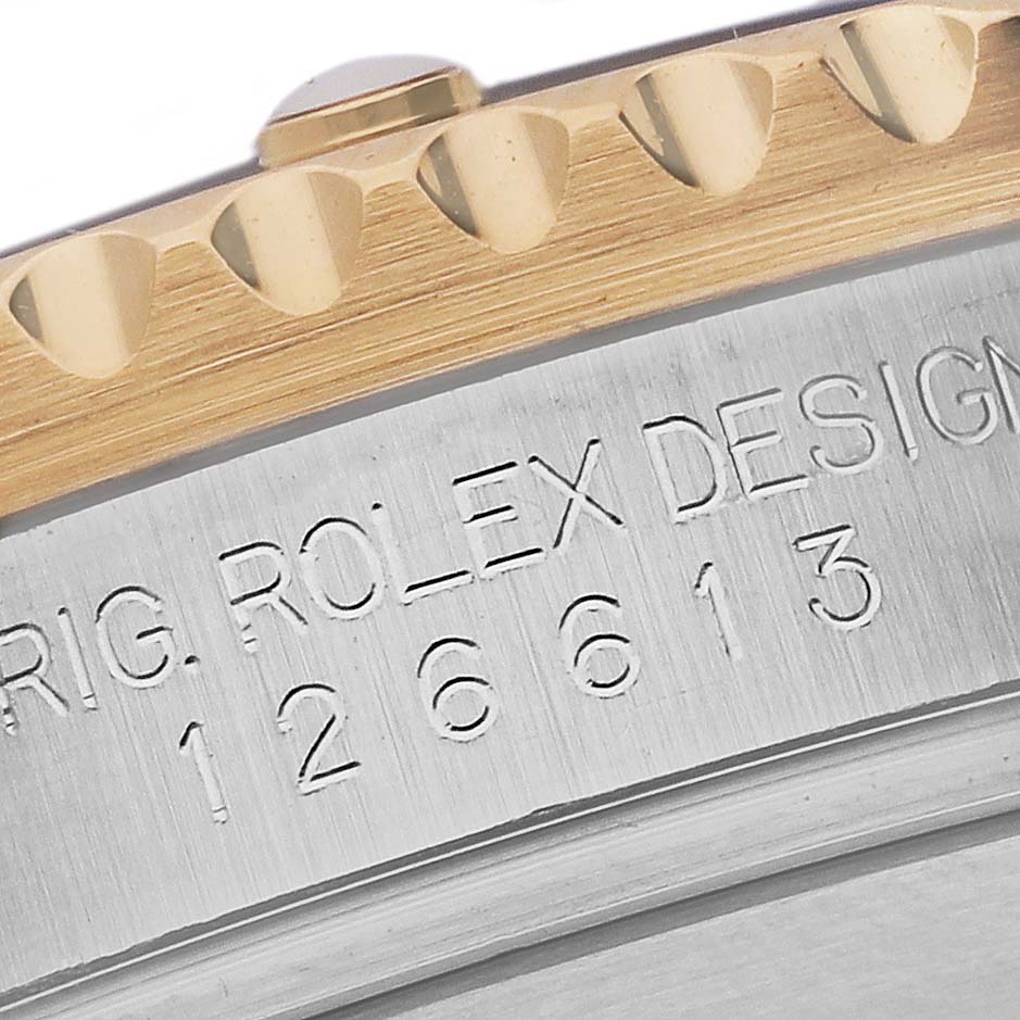 The image shows a close-up view of the side of the Rolex Submariner 126613LB Men's Steel and Gold (two tone) Blue Dial 126613LB Men's Steel and Gold (two tone) Blue Dial, focusing on the engraved design and part of the bezel.
