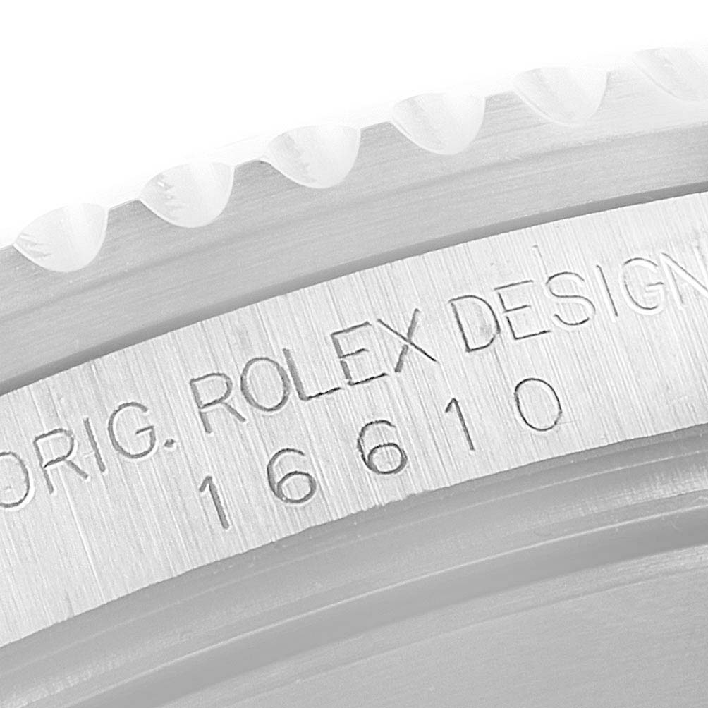 The image shows an angled close-up of the side of a Rolex Submariner 16610 Men's Stainless Steel Black Dial 16610 Men's Stainless Steel Black Dial watch with the model number (16610) and "ROLEX DESIGN" engraving.
