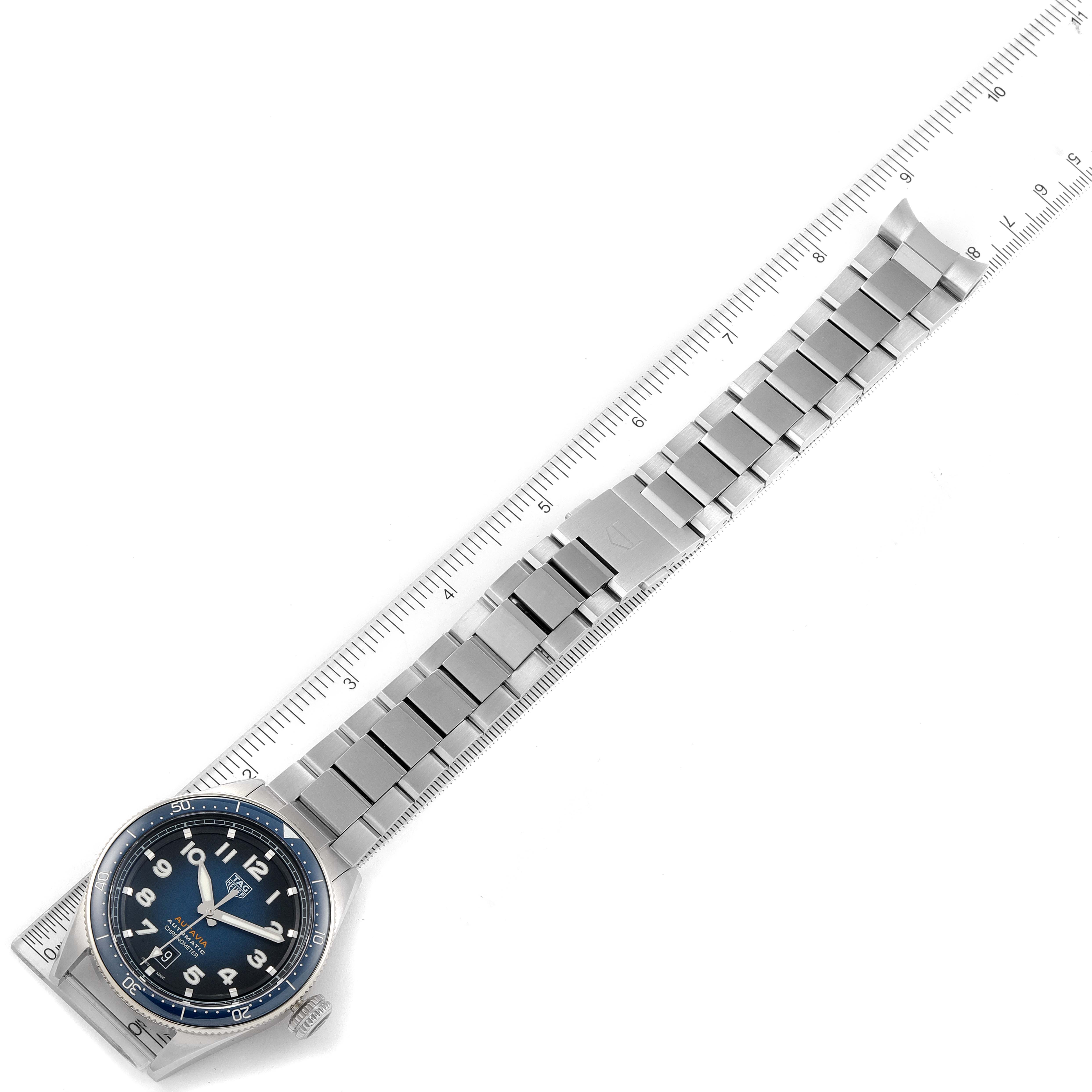 The image shows the front view of a Tag Heuer Autavia WBE5116.EB0173 Men's Stainless Steel Blue Dial WBE5116.EB0173 Men's Stainless Steel Blue Dial model watch with its metal bracelet alongside a ruler for scale.