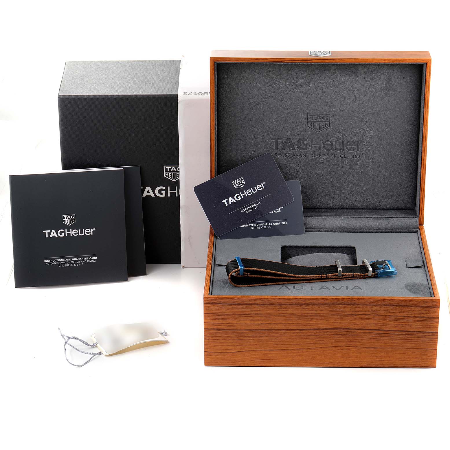 The image shows the packaging, instruction manual, and strap of an Autavia watch by TAG Heuer.