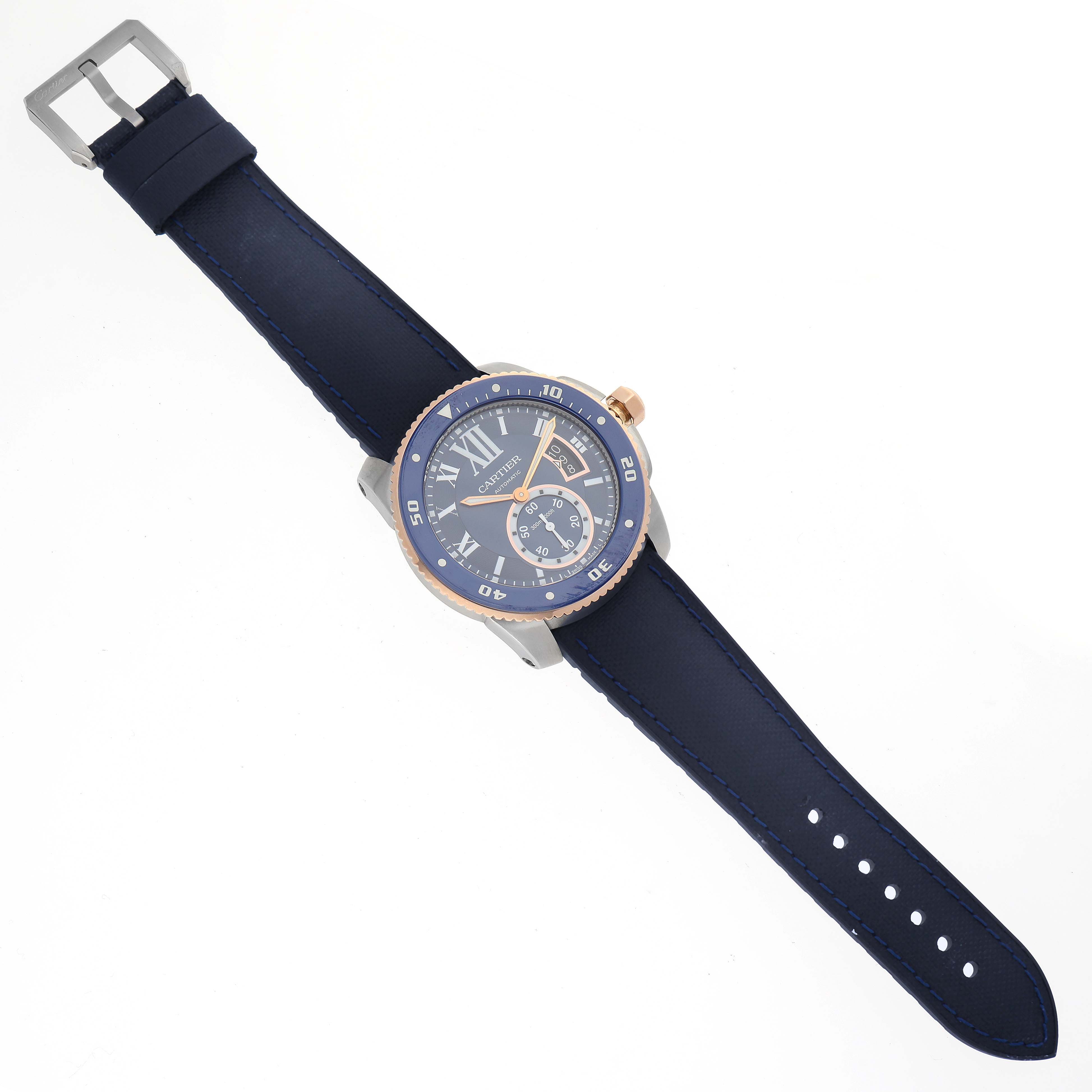 The image shows a top-down view of a Calibre de Cartier watch by Cartier, featuring its dial, bezel, and strap.