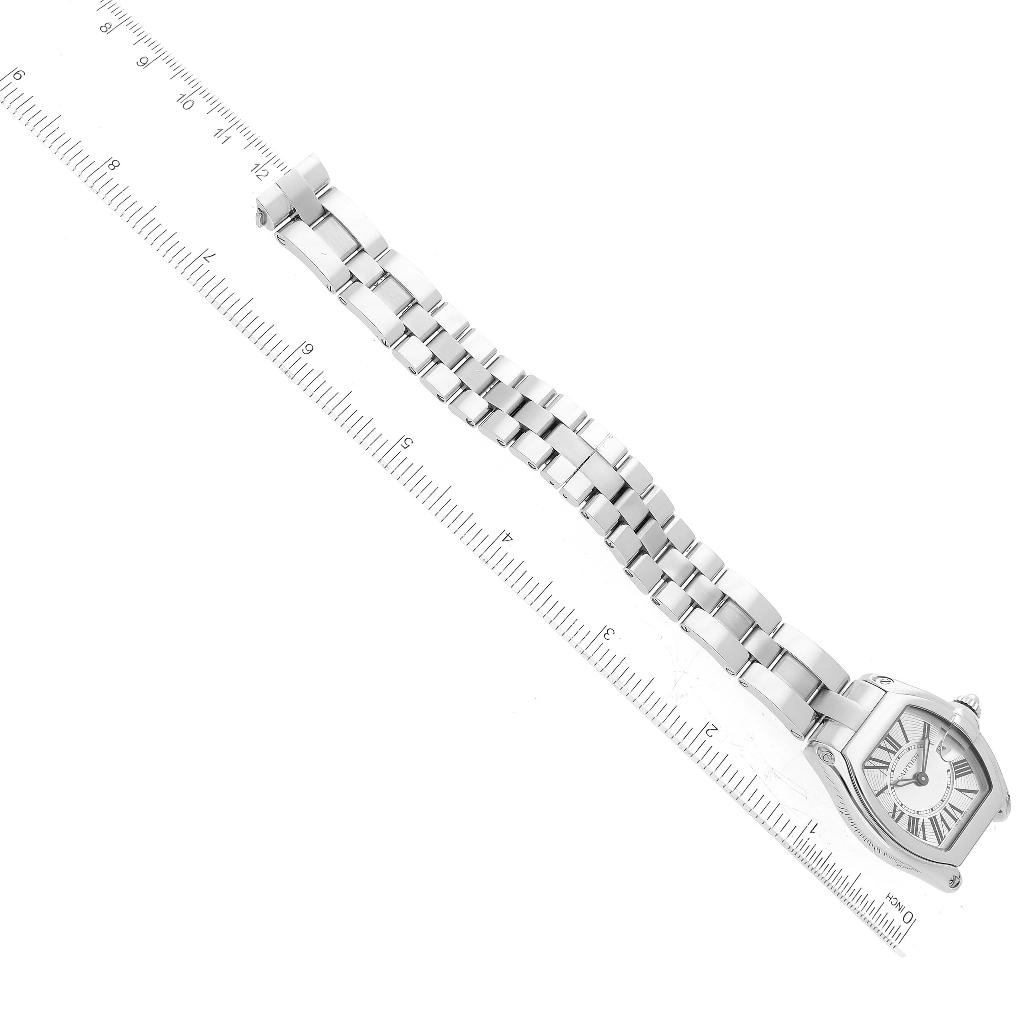 The image shows a full view of the Cartier Roadster W62016V3 Women
s Stainless Steel Silver Dial W62016V3 Women
s Stainless Steel Silver Dial watch and its metal bracelet, placed on a ruler for size reference.