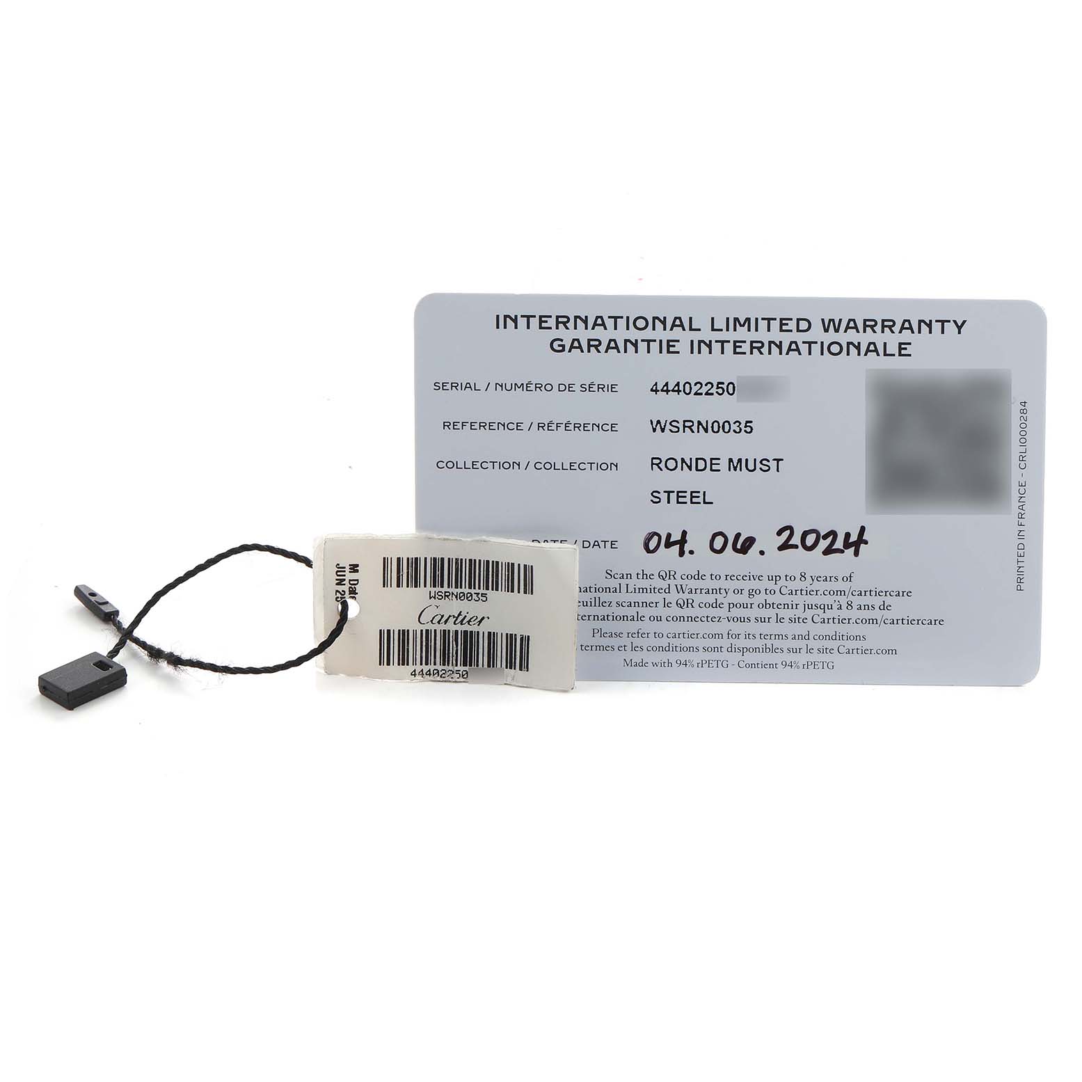 The image shows a Cartier Ronde WSRN0035 Men's Stainless Steel Silver Dial model warranty card and tag placed flat on a surface.