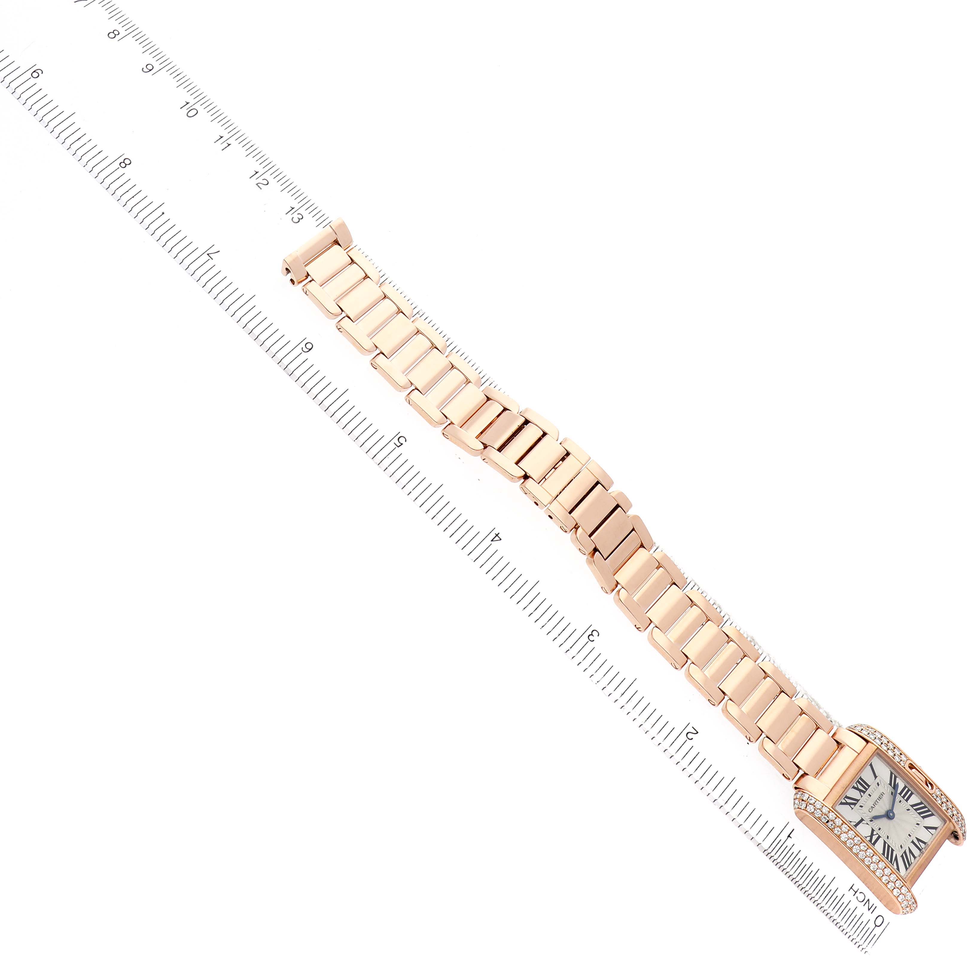 The Cartier Tank Anglaise WT100002 Women's Rose Gold Silver Dial watch is shown from a top view, displaying the face, rectangular case, and entire bracelet against a ruler.