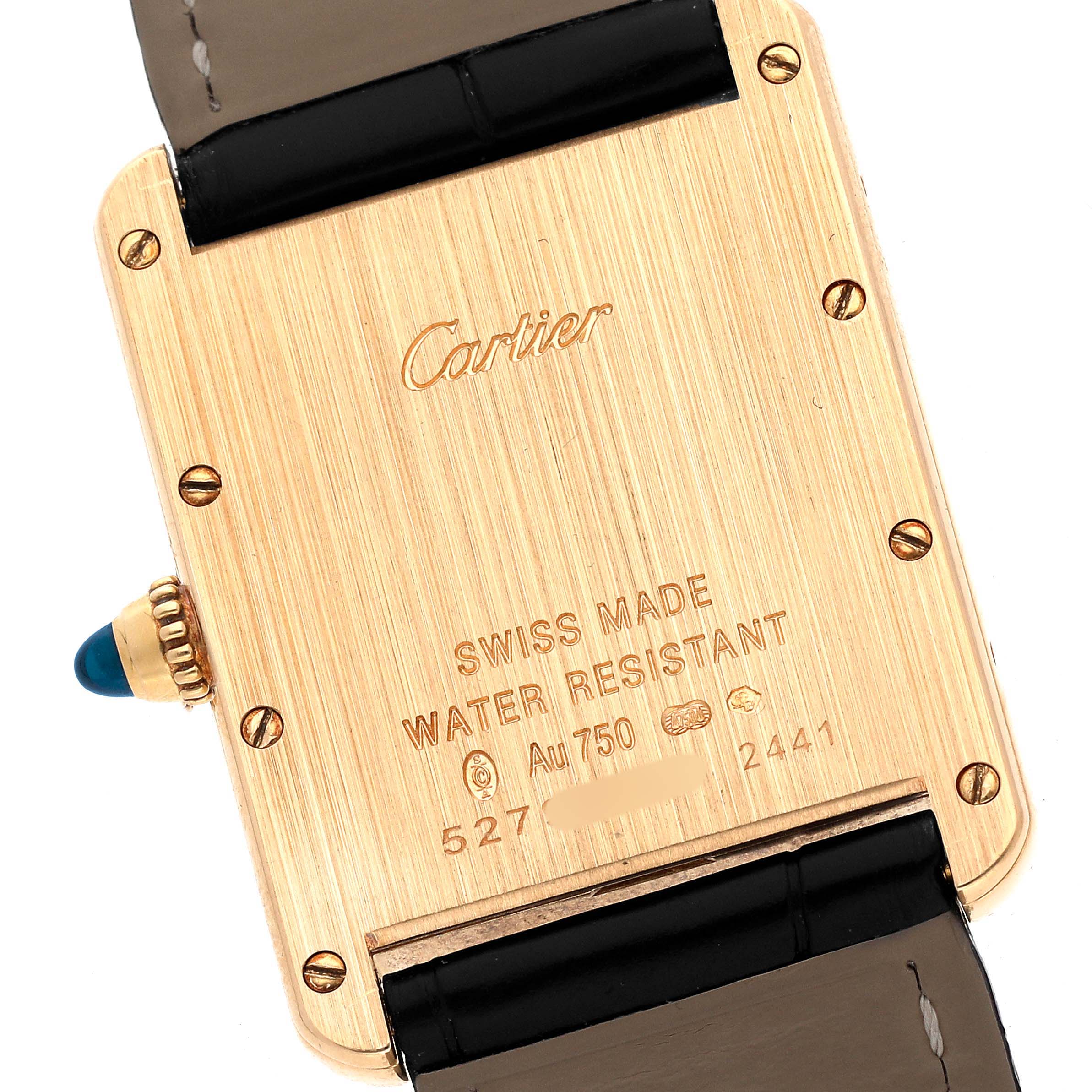 The image shows the back view of a Cartier Tank Louis W1529756 Men's Yellow Gold Silver Dial watch, highlighting the gold case, inscriptions, and strap attachment.
