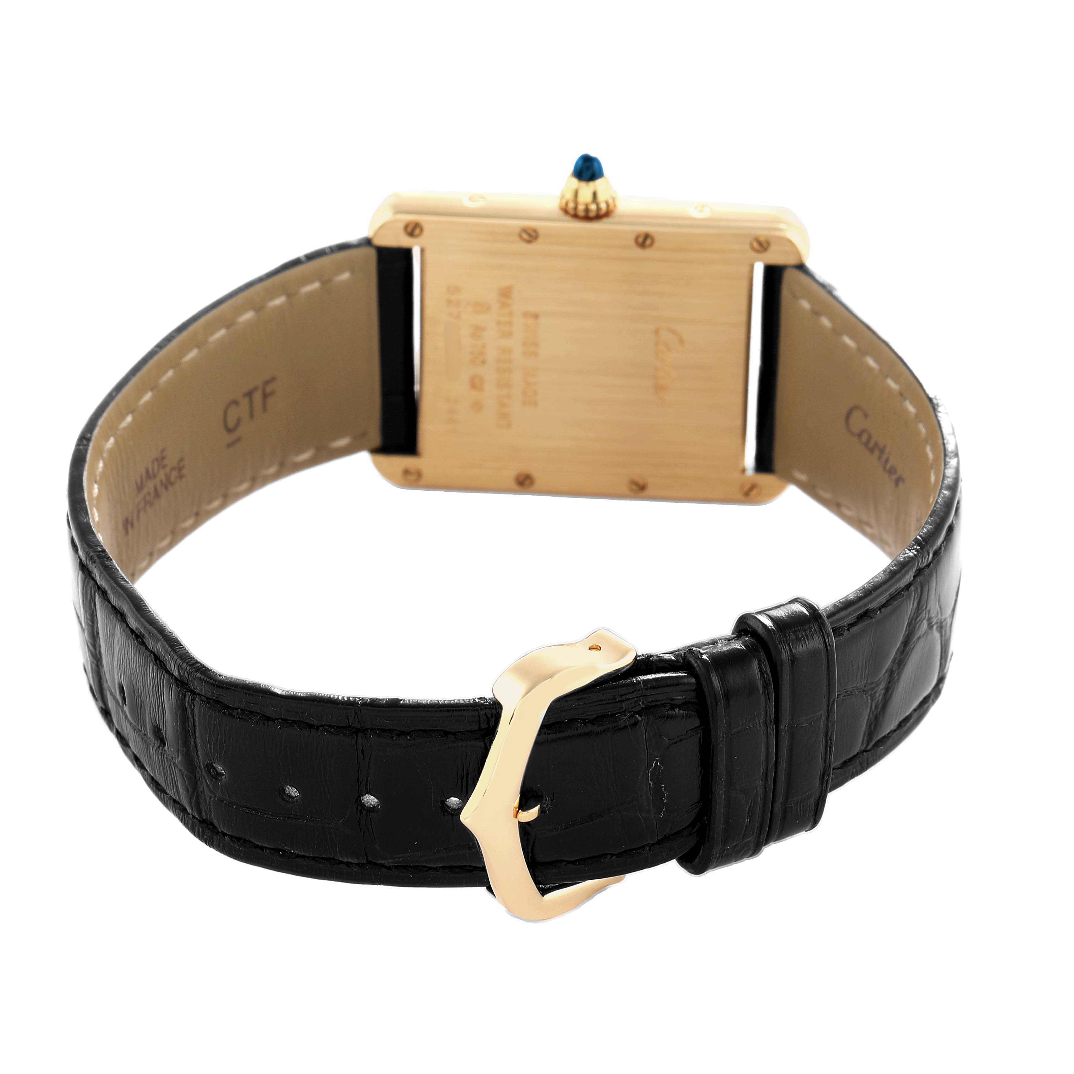 The Cartier Tank Louis W1529756 Men's Yellow Gold Silver Dial watch is shown from the back, highlighting its gold case, leather strap, and a visible crown with a blue gem.